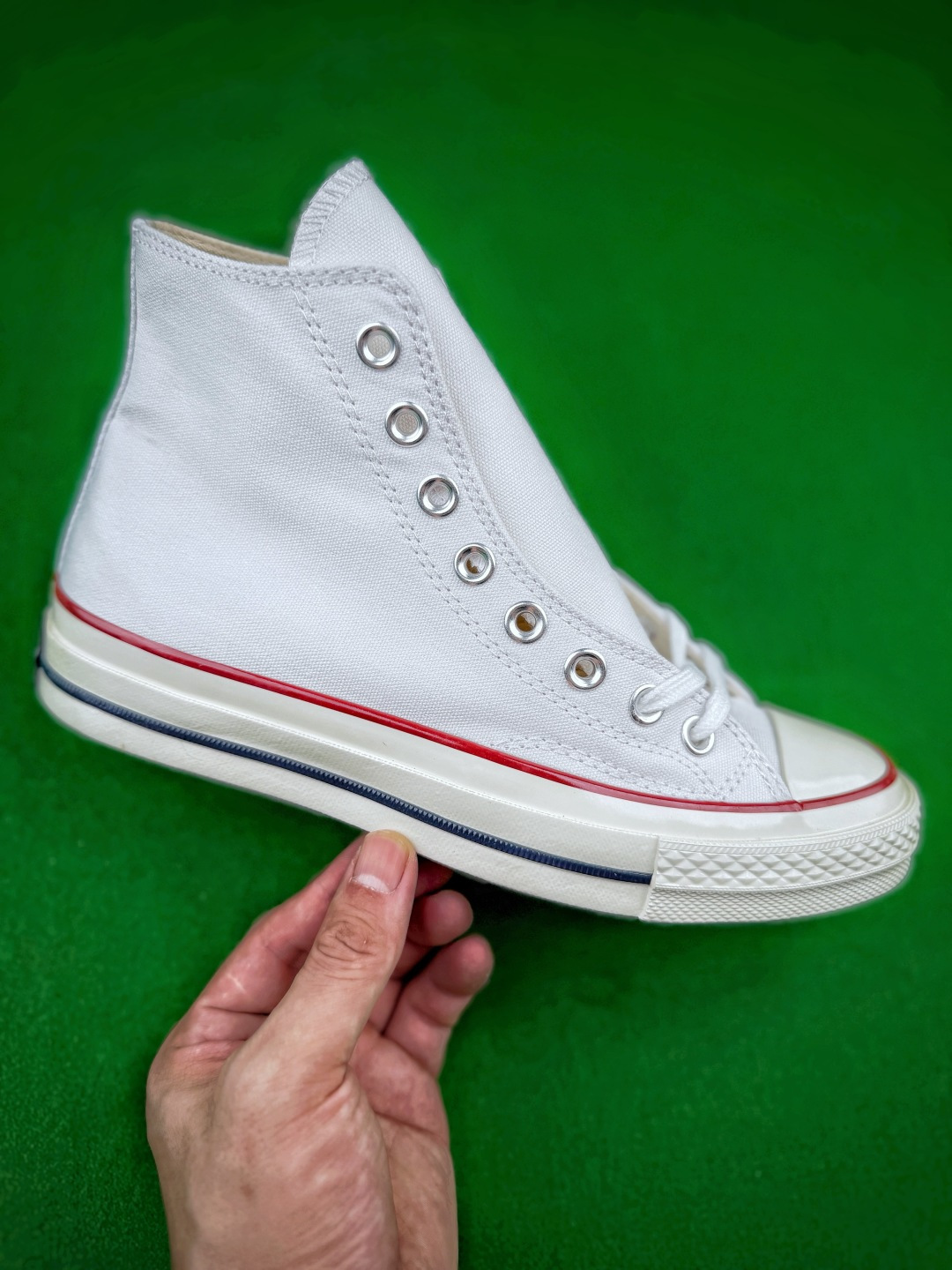 虎扑 区别市面通货 双围条小头Converse Chuck 70高帮帆布鞋，采用扎实耐磨的帆布打造鞋身，经典高低帮版型可以修饰腿部线条，金属鞋眼搭配棉质鞋带，穿脱灵活且贴合脚面，鞋头采用橡胶包头，有效防磕碰，鞋身保留标志性明线车缝工艺，细节质感突出。中底搭载加厚橡胶结构，脚感柔软，缓震表现优于基础款，侧边饰有细黑线条，外底是标志性的菱形颗粒橡胶纹路，防滑耐磨，兼顾日常行走的实用性，复古的版型适配多种穿搭风格，，不管是日常通勤、休闲出街都很合适，长久穿着不易快速疲劳，是百搭耐看的经典复古帆布鞋。Size 35 36 36.5 37 37.5 38 39 39.5 40 41 41.5 42 42.5 43 44 45 46 image 1