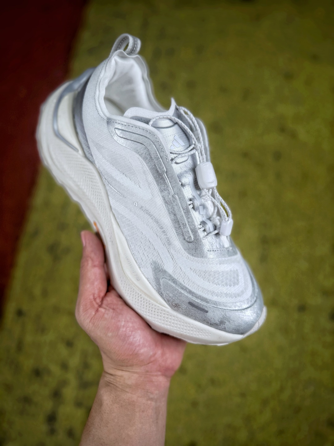 Adidas Holo Peak，鞋身采用工程提花抗撕裂网布，搭配多层热压塑形贴片加固鞋身轮廓，强化鞋头与侧向受力区域的防护能力，兼顾透气表现与户外抗剐蹭性能；快速调节锁扣鞋带系统，可一键收紧鞋仓，适配动态足部变化，鞋口内置高密度泡棉衬垫，后跟增设提拉织带，提升穿脱便捷度；中底采用轻量化高弹发泡材质，立体分层结构兼顾缓震回弹与侧向支撑，有效分散落地冲击力，稳定足部姿态；外底搭载Continental马牌橡胶，立体多向锯齿纹路，干湿路面都拥有可靠抓地效果，整体融合硬核户外机能设计与简约高质感，适合山野徒步、轻越野出行以及城市机能穿搭场景。Size 36 36.5 37 38 38.5 39 40 40.5 41 42 42.5 43 44 45 image 1