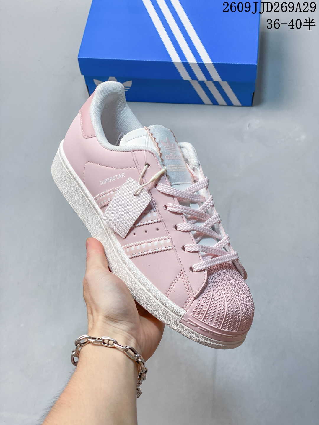 Adidas Superstar 粉色贝壳头板鞋 甜妹本命贝壳头来啦💖温柔浅粉鞋身，搭配格纹三条杠，细节满满。 经典贝壳鞋头，优质皮革鞋面，手感细腻好打理。米白中底，柔和不突兀，上脚清新减龄。 低帮版型，搭配裙子、牛仔裤、卫裤都很合适，少女感直接拉满。 尺码 36-40 半，多色可选，日常出街、约会穿搭首选！ 09JJD269A29 image 1