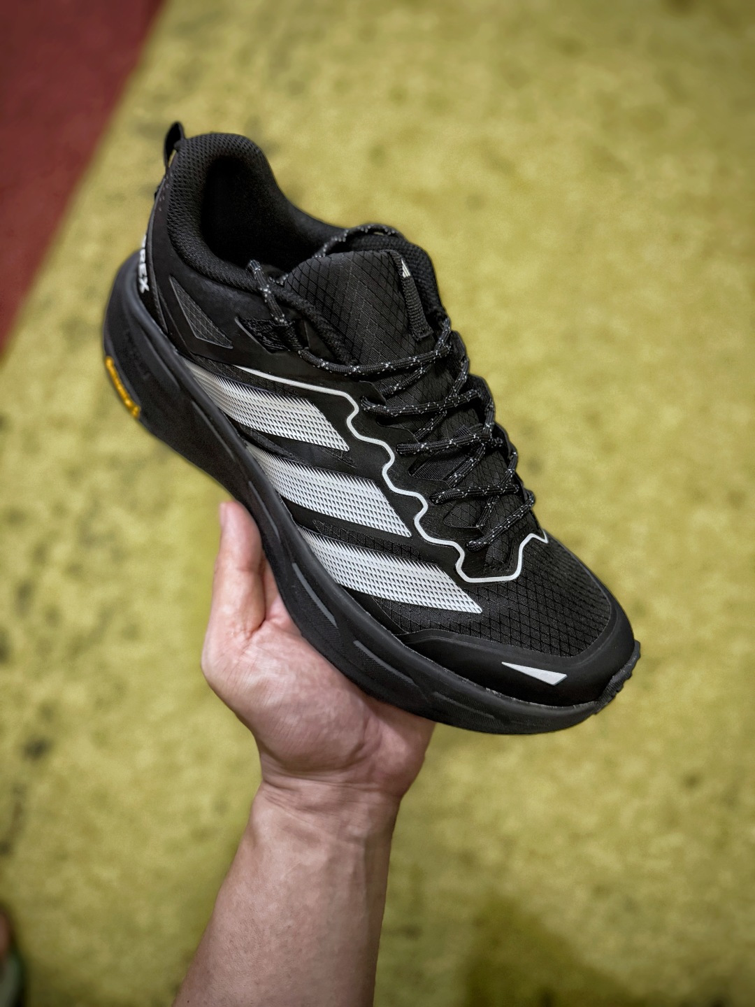 adidas TERREX FREEHIKER LT，整双鞋主打轻量户外实穿属性，鞋身选用抗撕裂格纹尼龙材质，表层带基础防泼属性，山间晨露、日常小雨不容易快速渗进鞋内；全身无多余车线，靠一体热压工艺把鞋面牢牢定型，久穿不容易松垮变形。专属免系弹力快拉鞋带设计，徒步时单手就能微调松紧，穿脱省时又可以牢牢锁住脚型。全掌加厚缓震中底带来平稳的推进脚感，长时间走路不容易累脚；标志性Vibram黄金橡胶外底，齿纹经过地形优化，面对湿滑石阶、砂石土路都有很强的附着摩擦力。鞋型不臃肿，上脚利落，尺码40‑45齐全，既能应对短途登山徒步，也是日常出门很有质感的机能风通勤选择 image 1