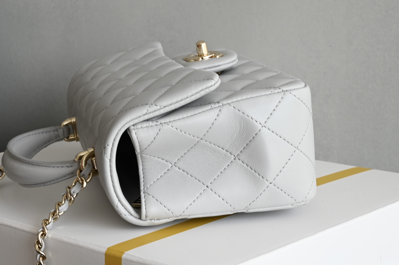 白金版▪️正品级 包装如图全新到货‼️𝟐𝟓𝐏 [升级版] 𝐌𝐢𝐧𝐢口盖包手提手腕 浅灰色带手柄的包包在近