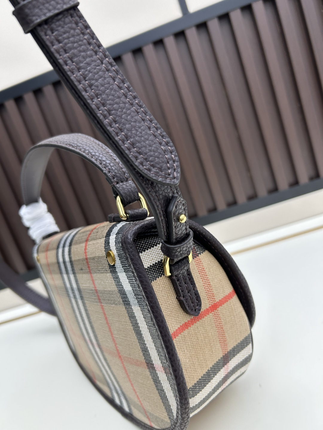 批280 Highlands 斜背包
汲取户外设计理念打造。选用棉质亚麻混纺面料，于意大利工坊精制而成，融入光滑小牛皮装饰和棉质内讨。
装饰提花精纺的 Burberry 格纹，设有风衣灵感涂层饰面。
搭配可拆式皮革肩背带，随心切换斜背 包和提柄包造型。尺寸24.5x8x 18cm 
型号8995.8996