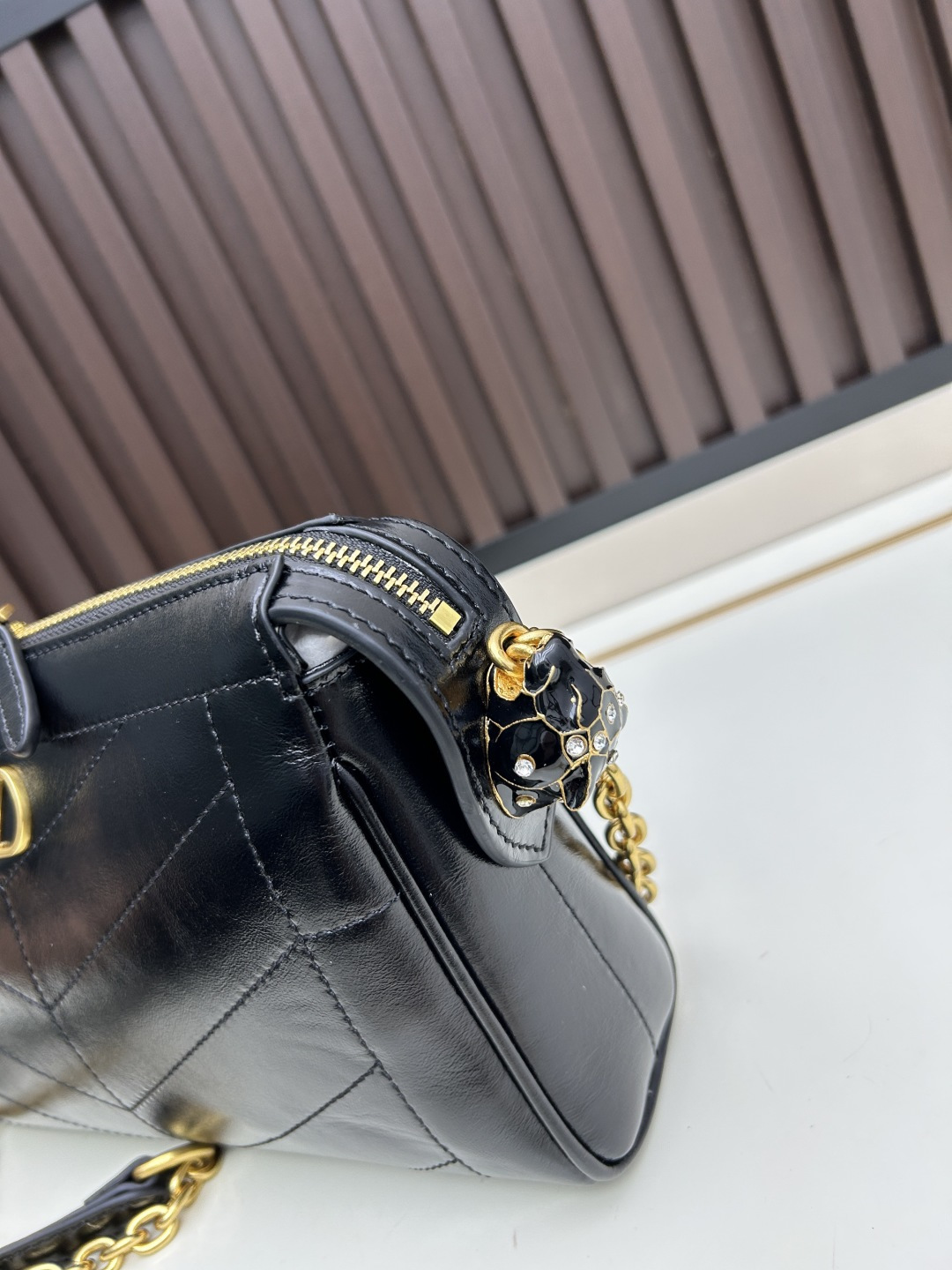 小号牛皮GARAVANI PANTHEA 手袋采用亮面和哑光羊皮革材质拼接出 V 形图案， 饰以珐琅兽头