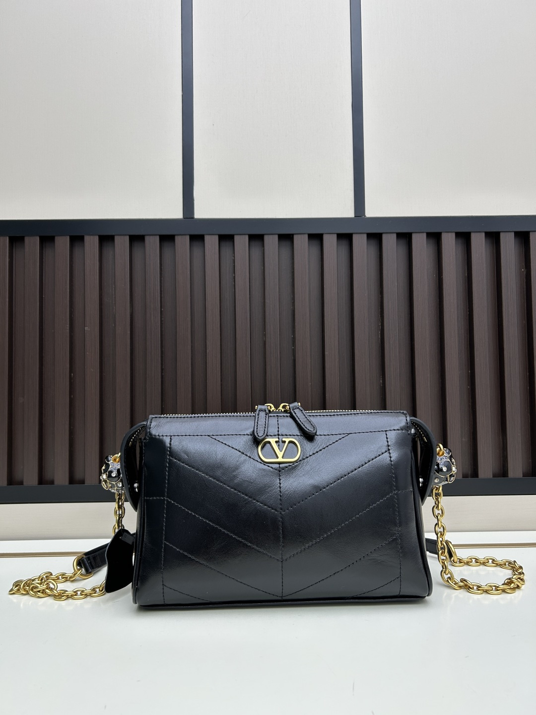 小号牛皮GARAVANI PANTHEA 手袋采用亮面和哑光羊皮革材质拼接出 V 形图案， 饰以珐琅兽头