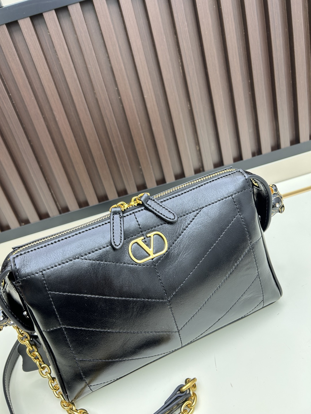 小号牛皮GARAVANI PANTHEA 手袋采用亮面和哑光羊皮革材质拼接出 V 形图案， 饰以珐琅兽头