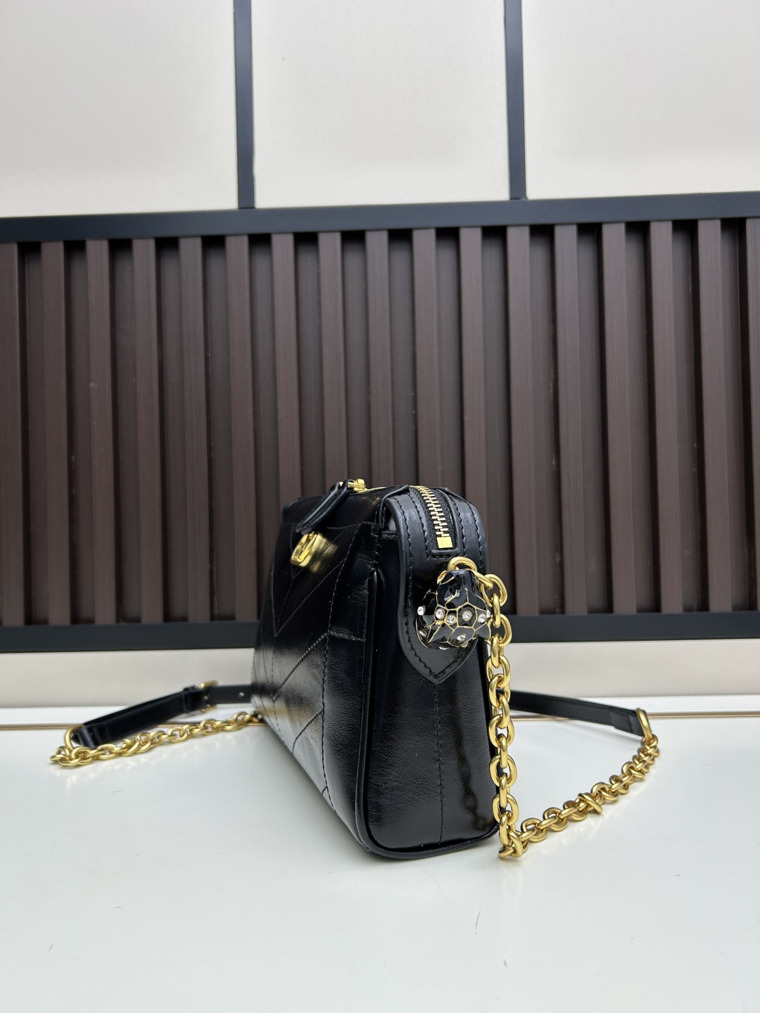 小号牛皮GARAVANI PANTHEA 手袋采用亮面和哑光羊皮革材质拼接出 V 形图案， 饰以珐琅兽头