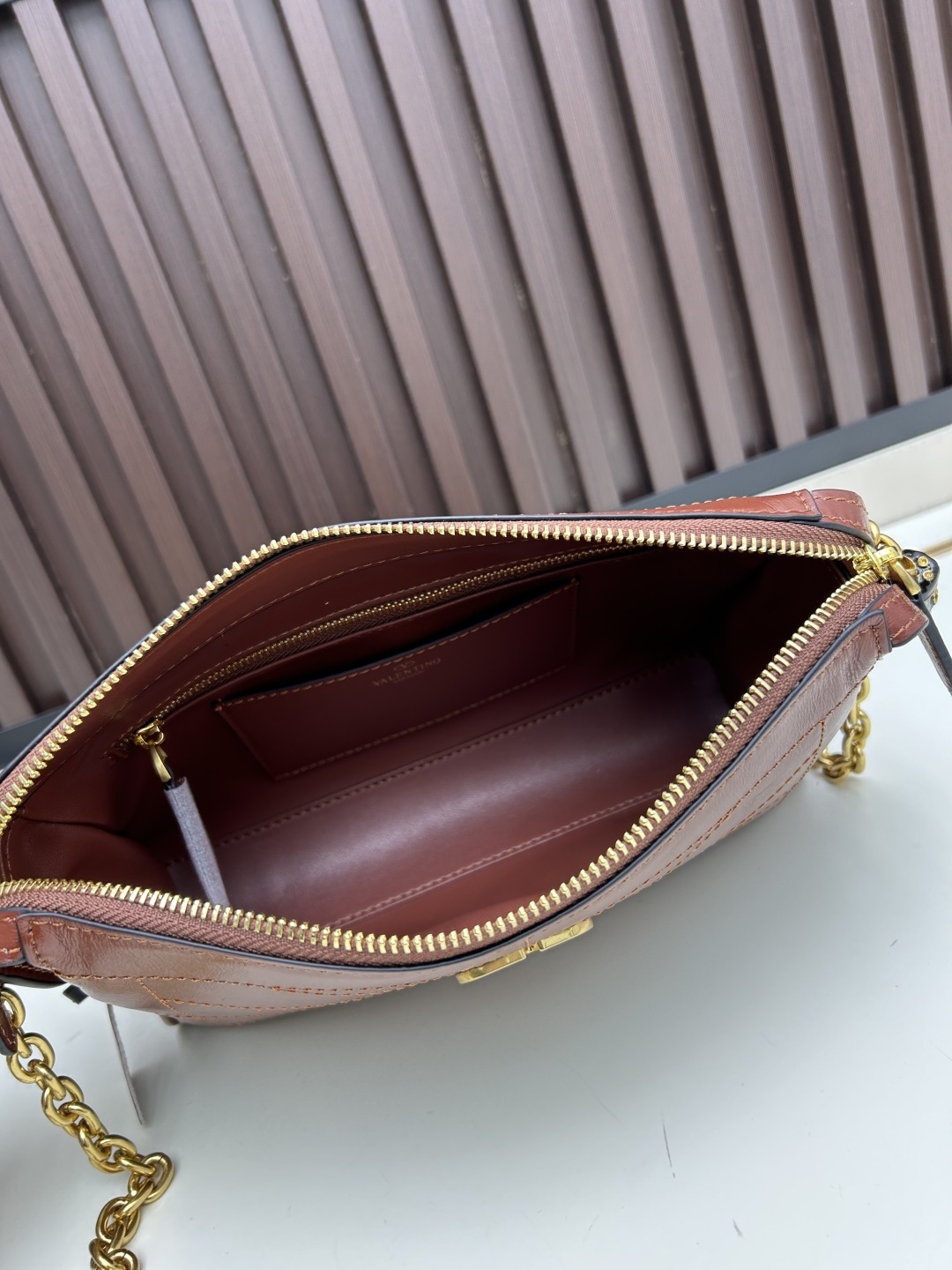 小号牛皮GARAVANI PANTHEA 手袋采用亮面和哑光羊皮革材质拼接出 V 形图案， 饰以珐琅兽头