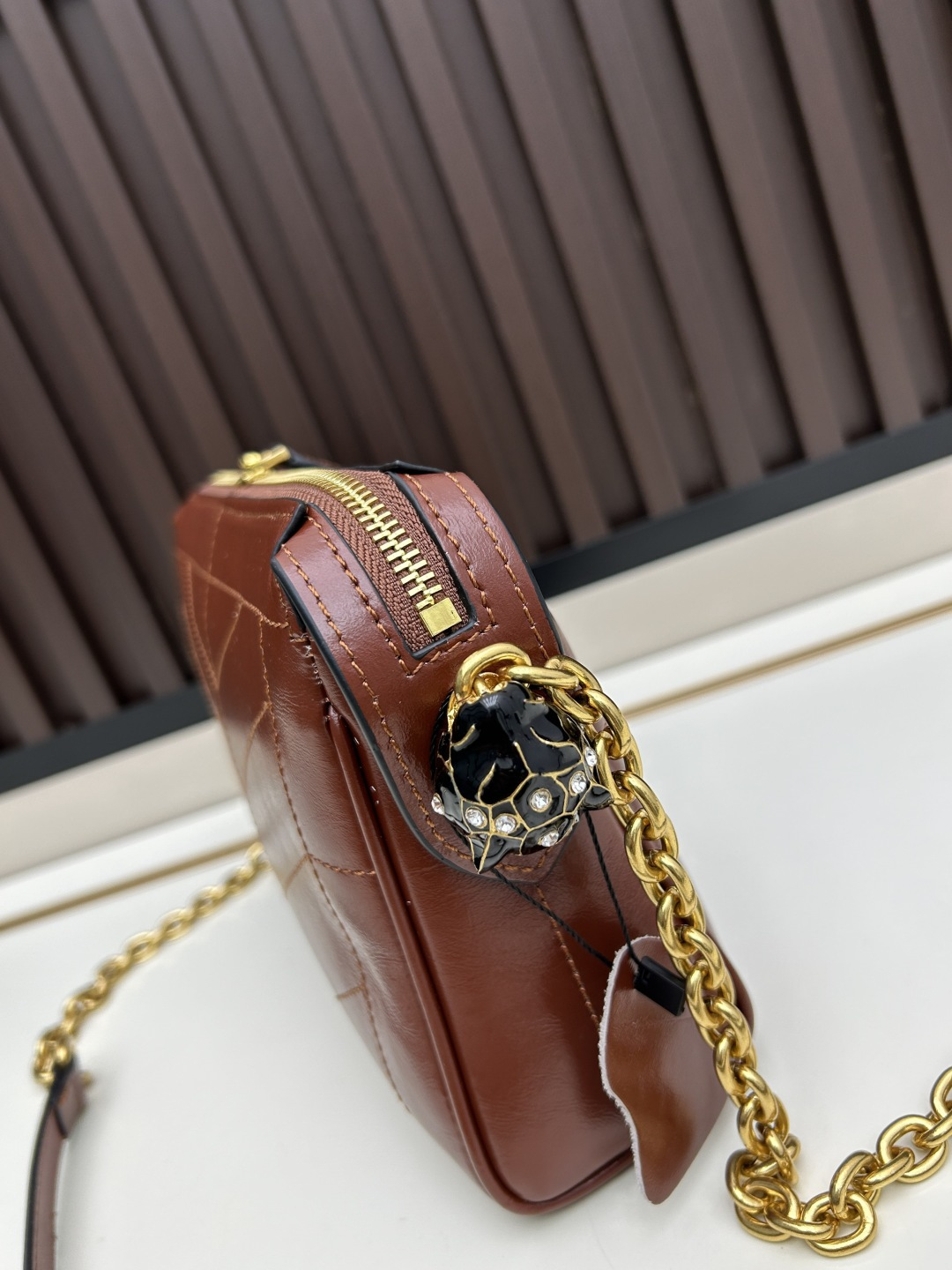 小号牛皮GARAVANI PANTHEA 手袋采用亮面和哑光羊皮革材质拼接出 V 形图案， 饰以珐琅兽头