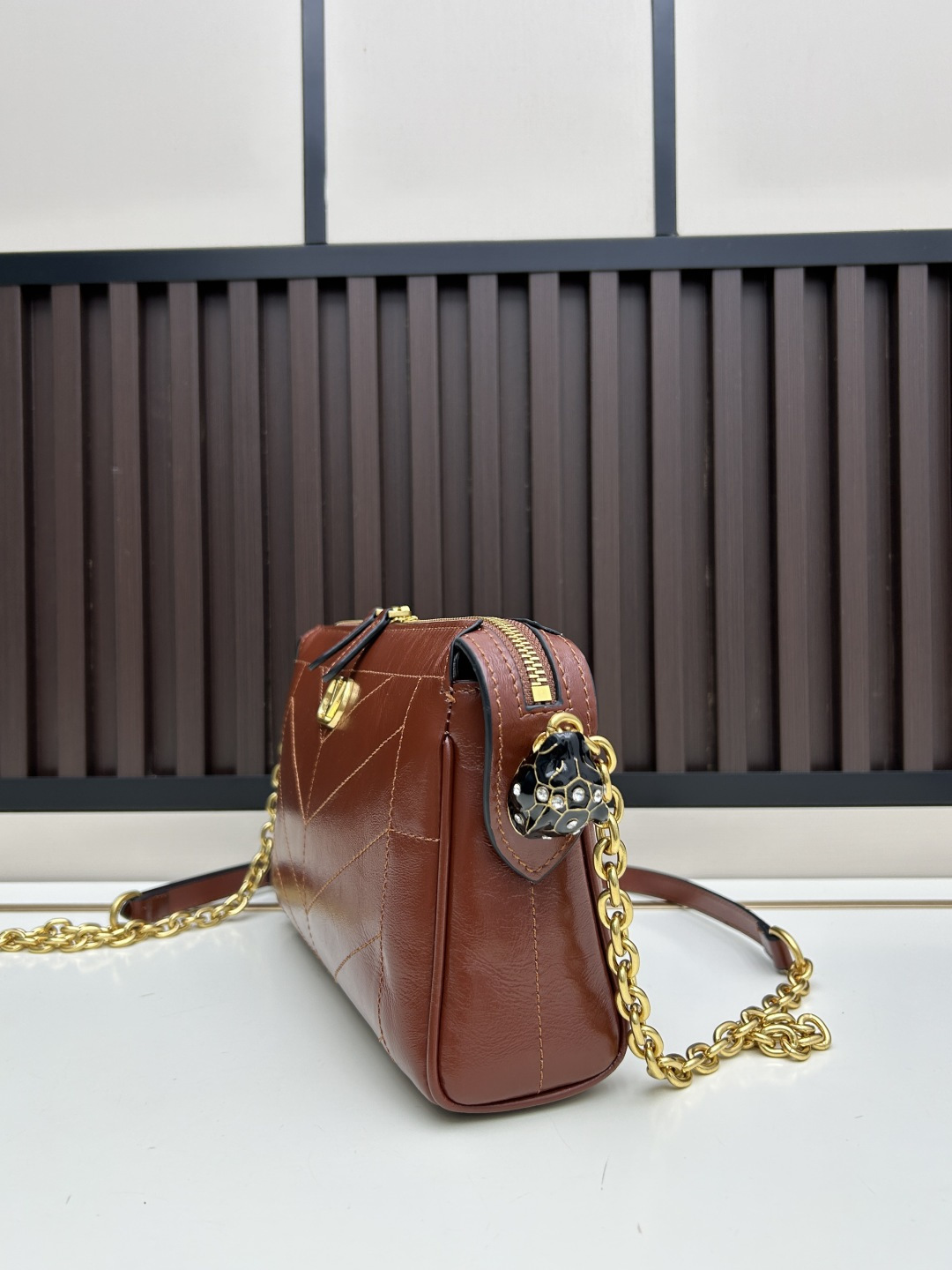 小号牛皮GARAVANI PANTHEA 手袋采用亮面和哑光羊皮革材质拼接出 V 形图案， 饰以珐琅兽头