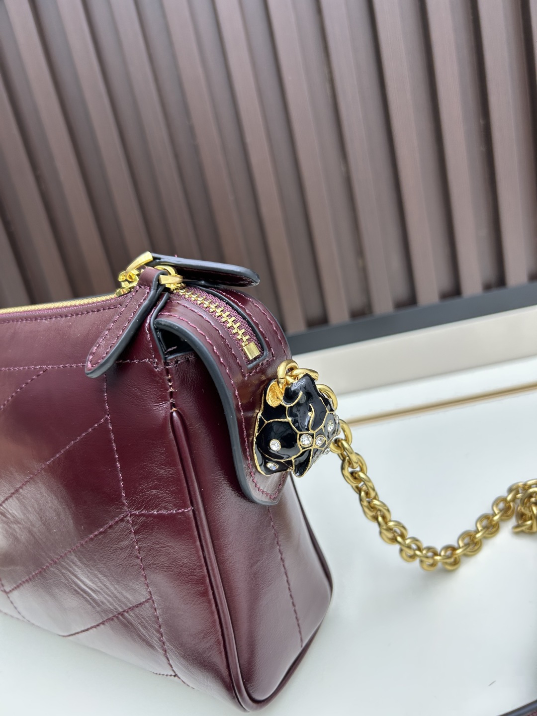 小号牛皮GARAVANI PANTHEA 手袋采用亮面和哑光羊皮革材质拼接出 V 形图案， 饰以珐琅兽头