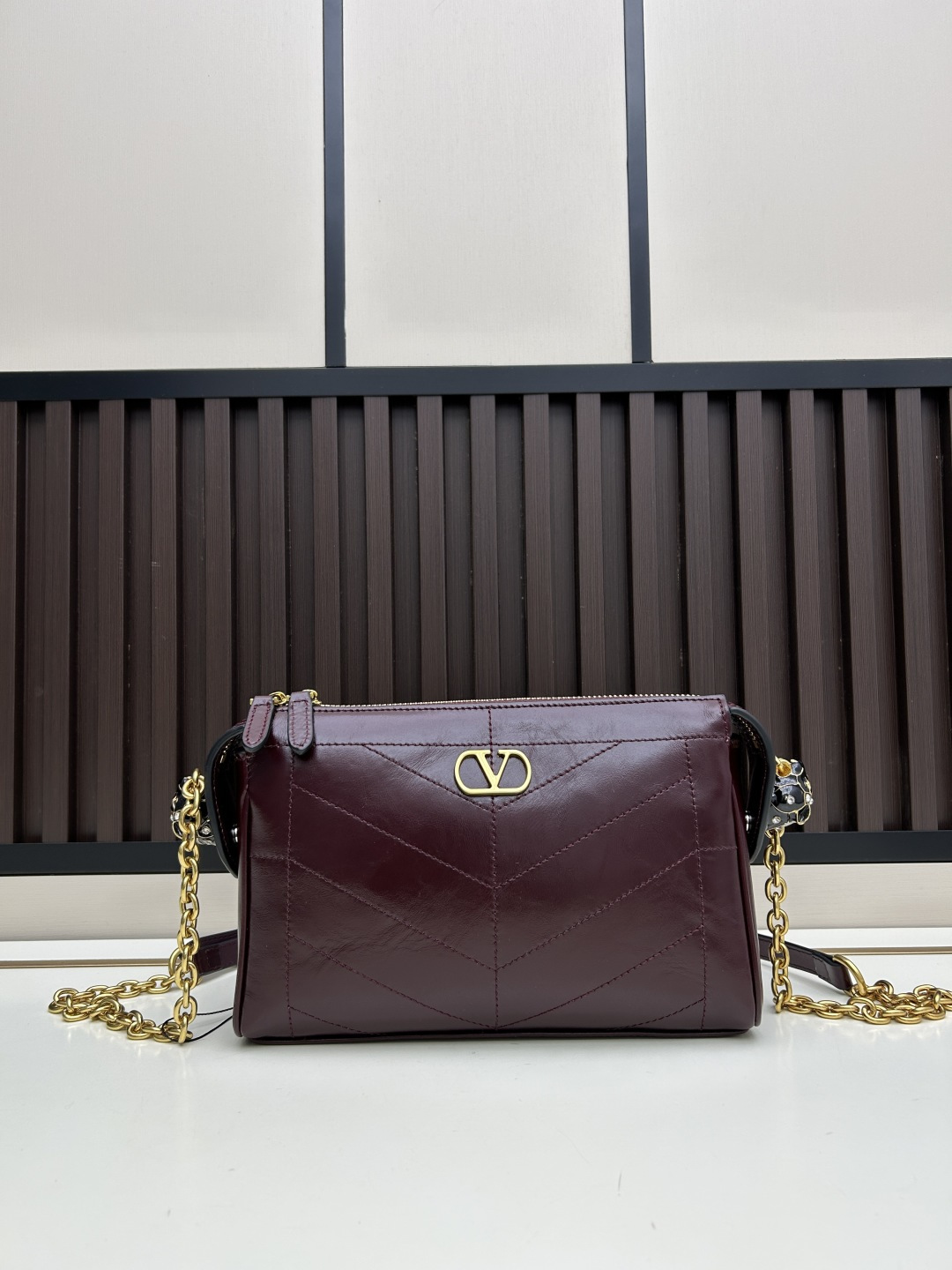 小号牛皮GARAVANI PANTHEA 手袋采用亮面和哑光羊皮革材质拼接出 V 形图案， 饰以珐琅兽头