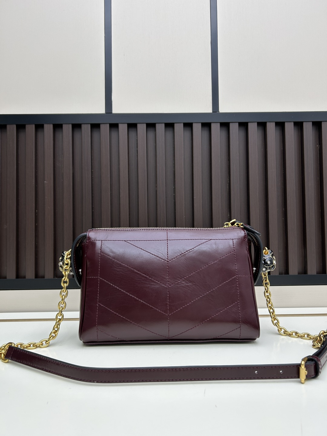 小号牛皮GARAVANI PANTHEA 手袋采用亮面和哑光羊皮革材质拼接出 V 形图案， 饰以珐琅兽头