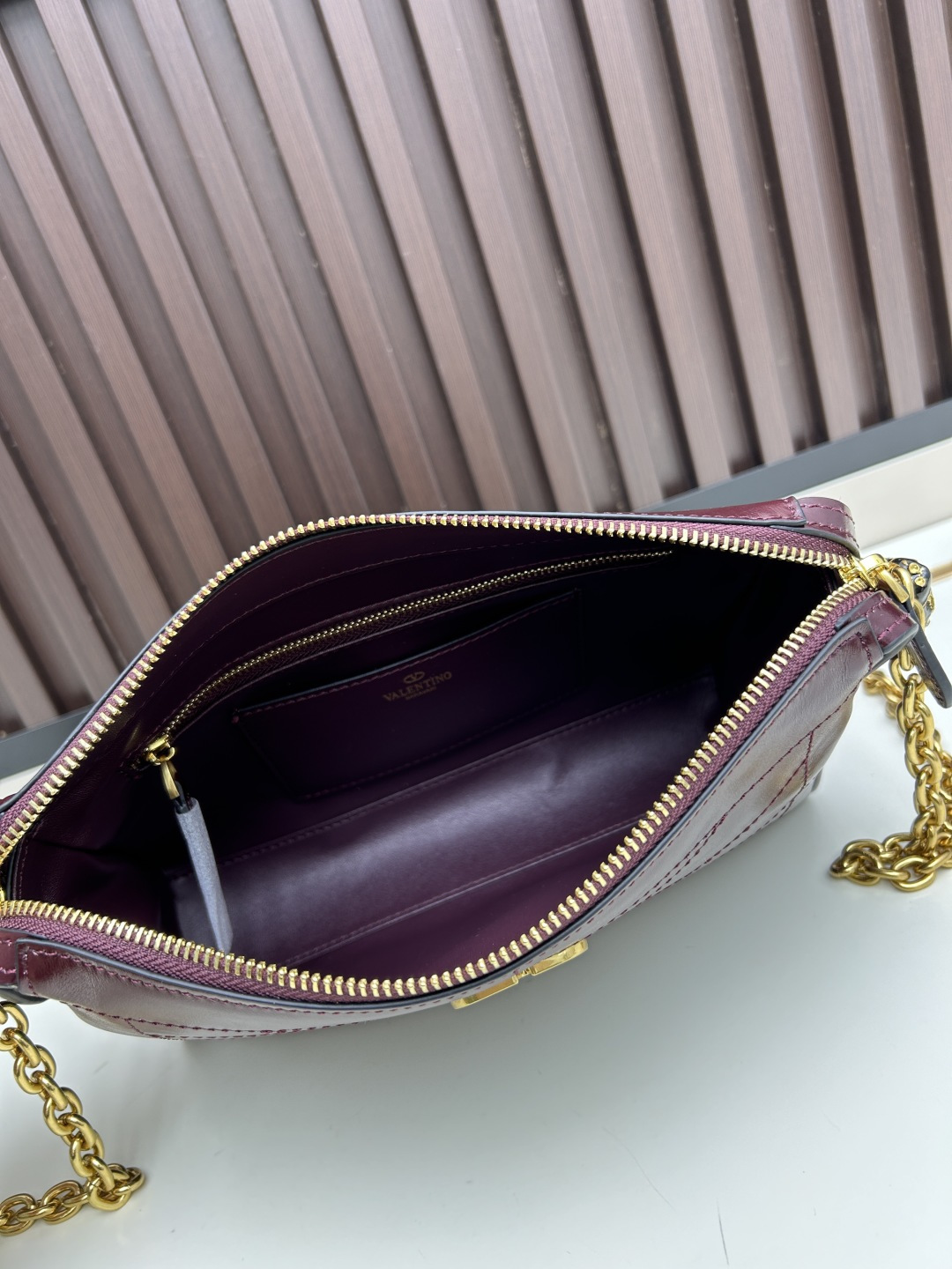 小号牛皮GARAVANI PANTHEA 手袋采用亮面和哑光羊皮革材质拼接出 V 形图案， 饰以珐琅兽头