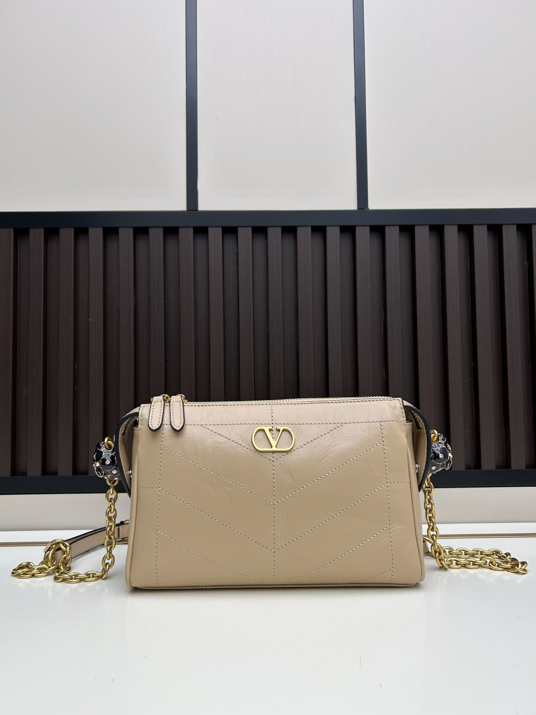 小号牛皮GARAVANI PANTHEA 手袋采用亮面和哑光羊皮革材质拼接出 V 形图案， 饰以珐琅兽头