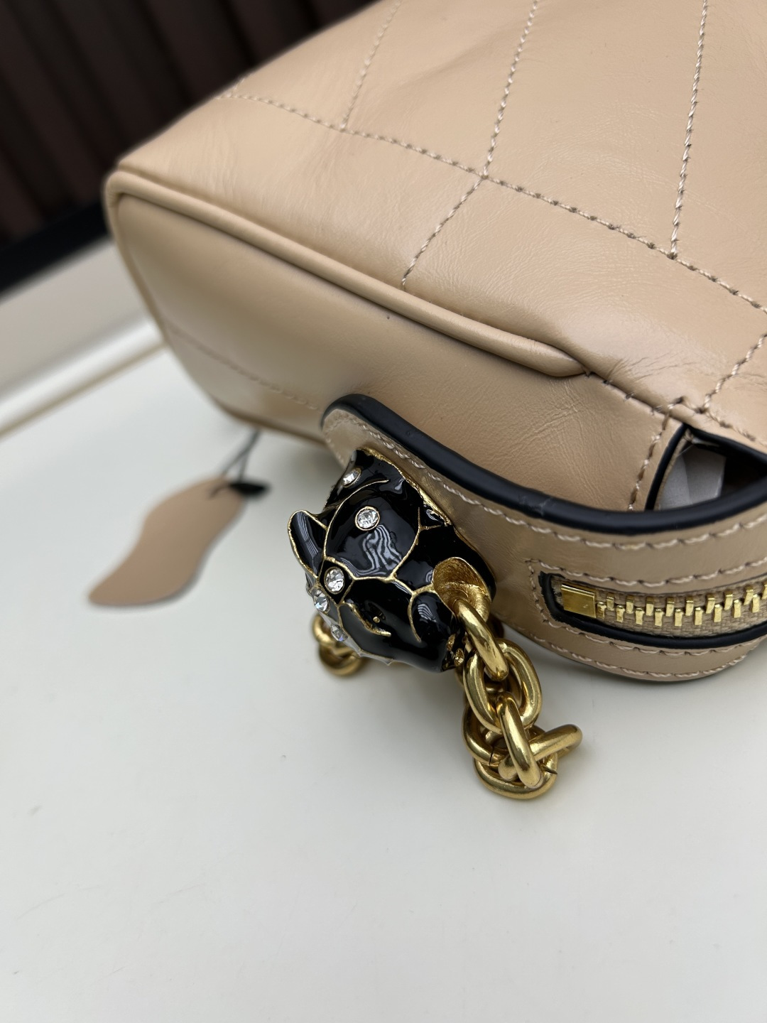 小号牛皮GARAVANI PANTHEA 手袋采用亮面和哑光羊皮革材质拼接出 V 形图案， 饰以珐琅兽头