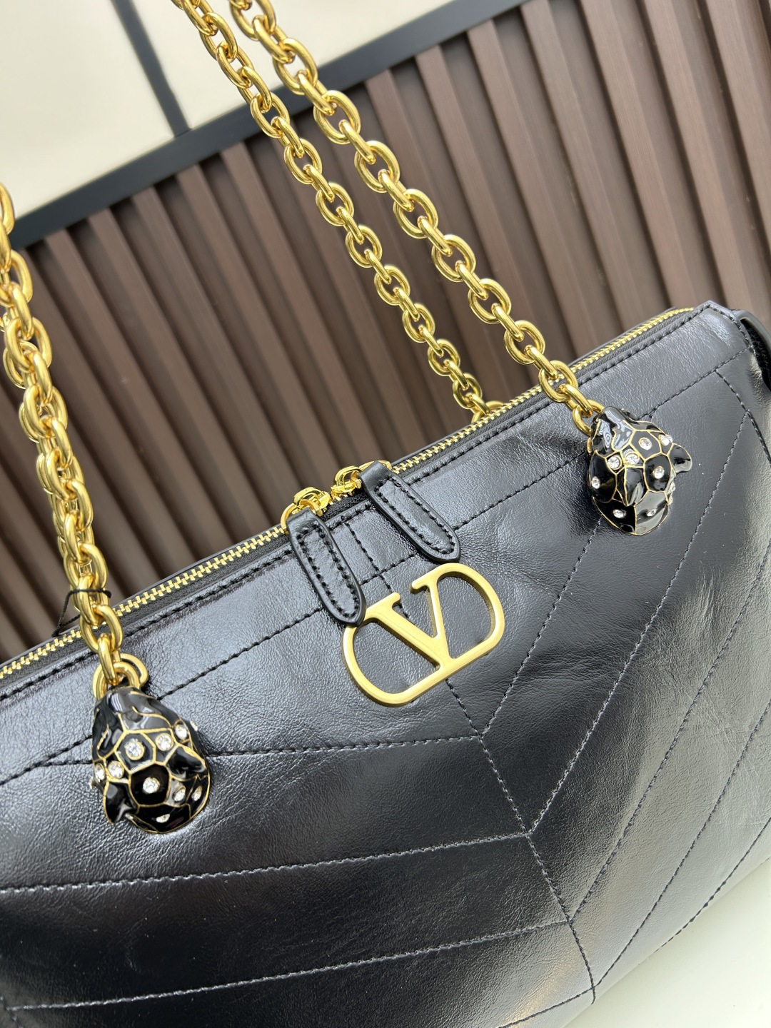 大号牛皮GARAVANI PANTHEA 手袋采用亮面和哑光羊皮革材质拼接出 V 形图案， 饰以珐琅兽头