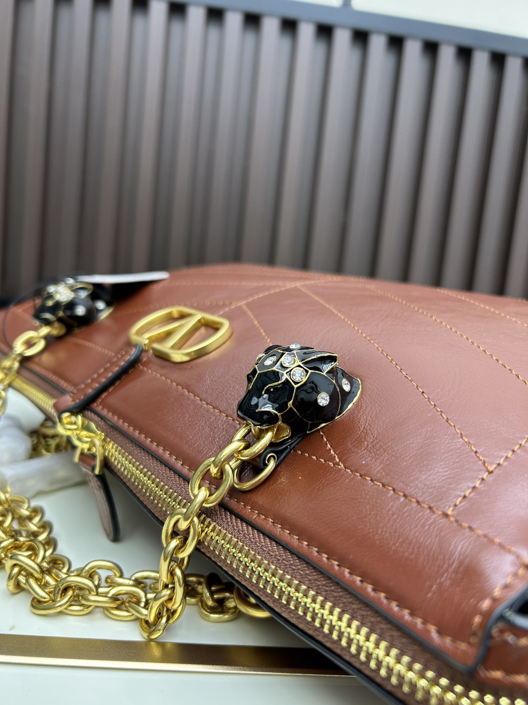 大号牛皮GARAVANI PANTHEA 手袋采用亮面和哑光羊皮革材质拼接出 V 形图案， 饰以珐琅兽头