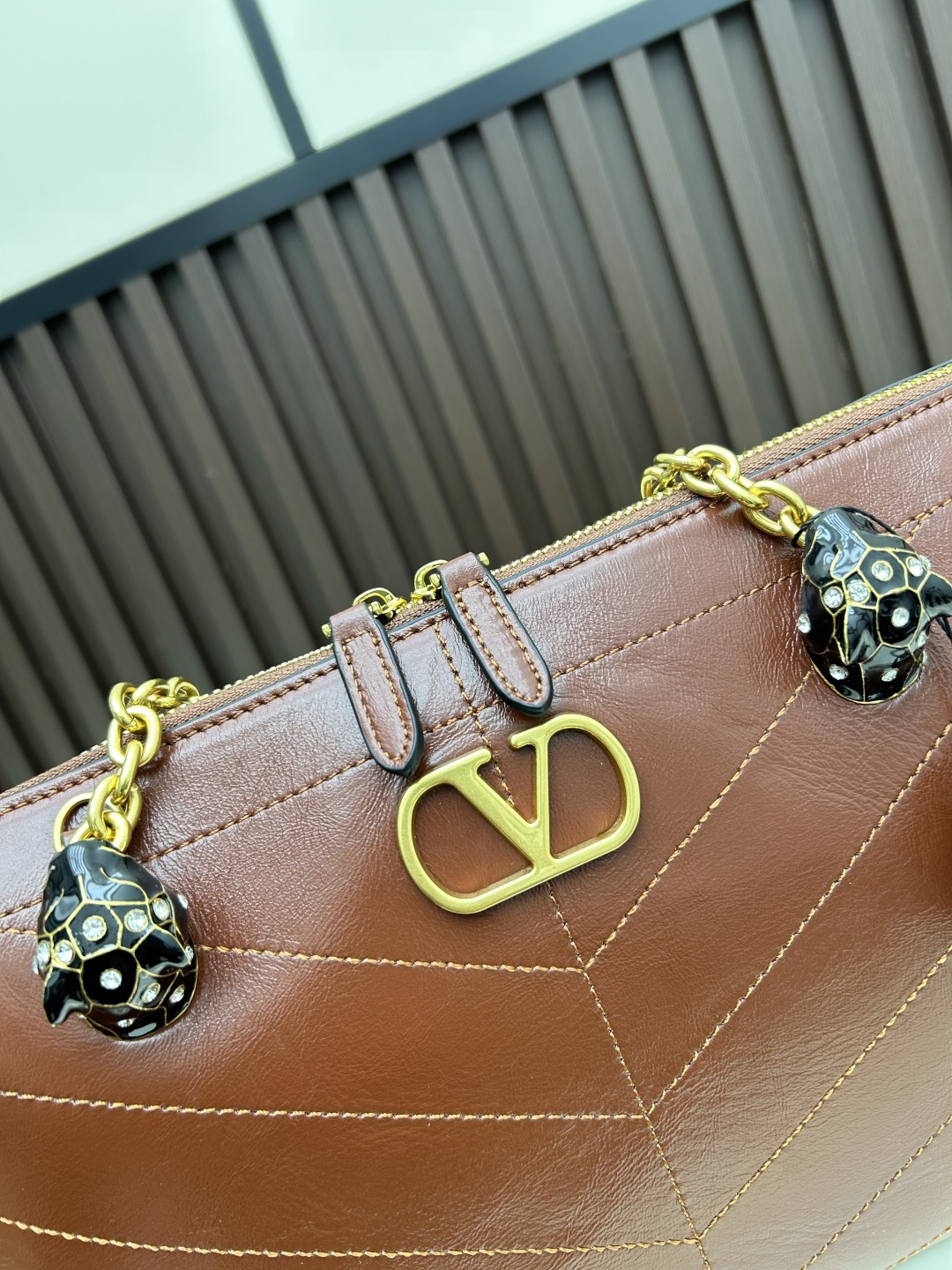 大号牛皮GARAVANI PANTHEA 手袋采用亮面和哑光羊皮革材质拼接出 V 形图案， 饰以珐琅兽头