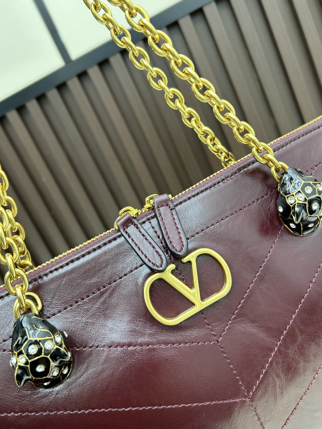 大号牛皮GARAVANI PANTHEA 手袋采用亮面和哑光羊皮革材质拼接出 V 形图案， 饰以珐琅兽头