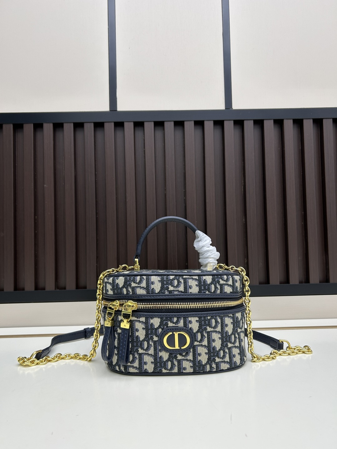 小号批460
dior	30 montaigne 迷你vanity 手袋「黑色」	
这款 30 montaigne 迷你vanity手袋设计精巧，兼具实用功能与高雅气质，为该系列提升格调。采用蓝色oblique 印花面料精心制作，正面饰以cd 标志提升格调。可收纳各种日常用品，设有一个内部口袋和镜子，更显精致。可通过手柄手提，搭配可调节肩带，以金色饰面金属和蓝色珐琅链环相间交错打造，饰以皮革镶片，可肩背或斜挎。正面饰以 cd 标志
拉链开合搭配 cd拉链头顶部手柄
1个隔层搭配镜子内部贴袋
可调节、可拆卸的皮革肩带
型号:7099
大尺寸:20.5x12.8x13.5厘米(长x高x宽)
小尺寸:16.5x8x9.5厘米(长x高x宽)可收纳1部手机、1个卡夹和唇膏