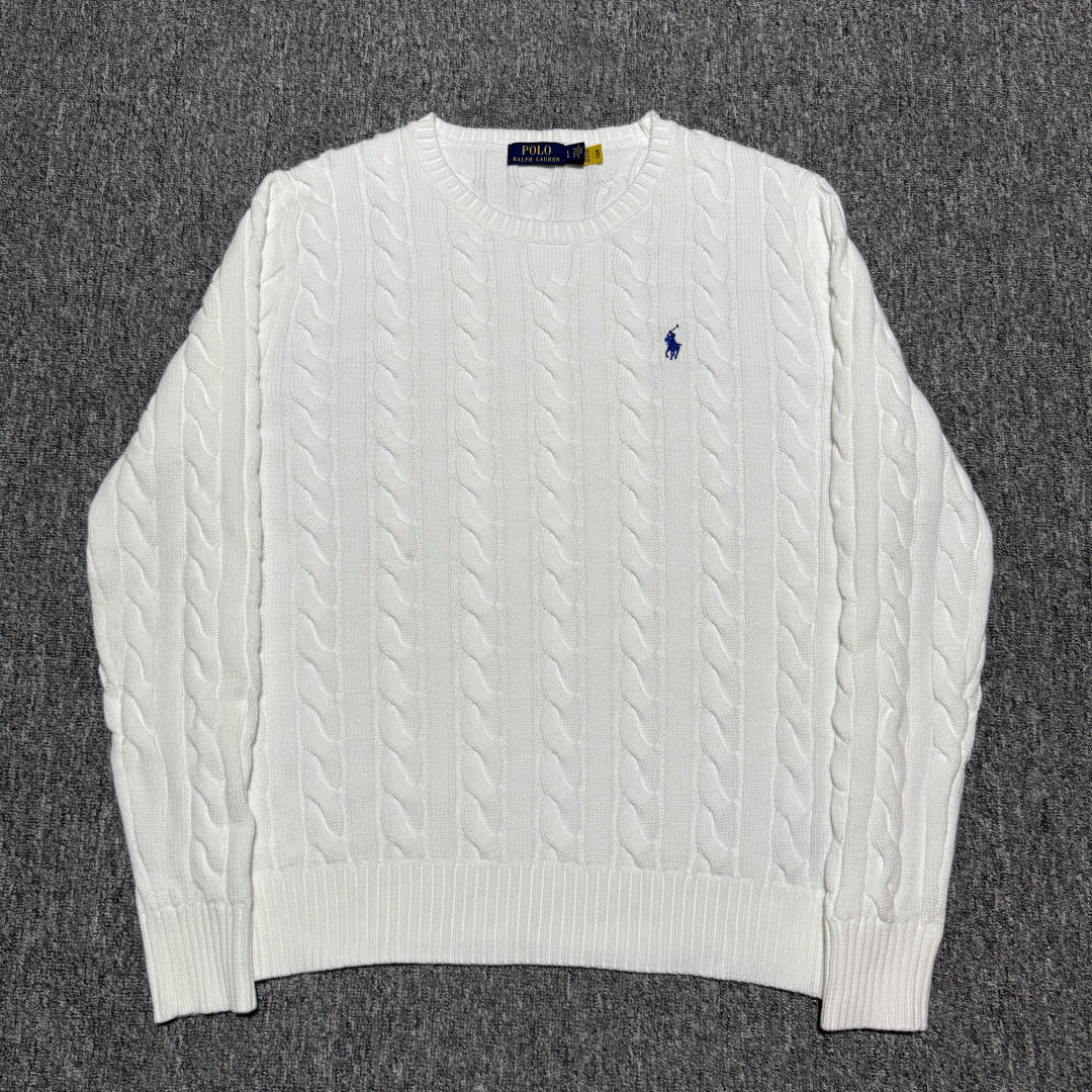 💰240  S# Ralph Lauren 拉夫劳伦 圆领绞花针织长袖毛衣 高端零售专供 品质保证 100%放心出街 尺码：S M L XL 编号：29OFTT82

面料克重： 380gsm 重磅毛衣的克重范围，确保了毛衣的挺括感、垂坠感和优异的保暖性。绞花图案需要足够的厚度才能立体突出

成分：100% 精纺新疆长绒棉 
既然是纯棉版，则使用100% 长绒棉。长绒棉纤维更长、强度更高、手感更柔软光滑，抗起球性优于普通棉花，是高端棉制品的首选

纱线工艺：
1.纺纱：使用精梳棉纱，去除了短纤维和杂质，纱线更光滑、坚固，不易起球。
2.合股：采用双股或多股纱线合捻编织。这大大增加了纱线的强度和织物的厚度，同时减少了变形几率，使织物结构更稳定，手感更丰满。
3.染色：采用色织或纱线染色。先对纱线进行染色后再编织，这样颜色渗透均匀，色牢度高，织物色泽柔和有层次感。水洗后颜色保持度高

布料的织造工艺：
1.绞花编织： 采用手工感模拟编织或电脑提花编织。通过交叉和扭绞针法，在平针的基础上形成立体的绳状、菱形、蜂窝等凹凸感强烈的图案。扭绞的力度和密度必须均匀一致，图案对称。要求绞花图案清晰、饱满、立体，触感有明显的凹凸层次。花型对位准确，尤其是在肩线、袖窿等接缝处。
2.底衫组织： 使用罗纹组织作为衣摆、袖口和领口，提供良好的收束力和弹性。 衣身主体部分在绞花图案之间会使用平针组织作为背景，以衬托绞花的立体感。平针部分应平整、无歪斜、无漏针
 3.领口、袖口、下摆罗纹：
使用与主面料同质同源的纱线，采用高弹性的棉混纺纱线（棉+氨纶），确保弹性和回复力优于衣身，能有效防止松懈变形。
4.螺纹工艺：采用 2x2 罗纹编织
要求织紧密实，弹性好，恢复性强。接缝处需平整
5.肩部加固： 使用与主布颜色匹配的棉质编带
在肩线内部的接缝处嵌入加固带。这能有效防止厚重的毛衣因自重而导致肩部拉伸变形，保持版型持久挺括。这是区分普通毛衣和高品质毛衣的关键细节

 辅料的工艺细节要求：
洗水标/主标：二维码领标 扫码可进官网

缝线材质：使用优质哑光棉线 其强度和色泽与主面料相匹配。缝骨（接缝）处采用四线拷边机处理，结实耐用。拼接处要对位准确（特别是绞花图案的对接），线迹均匀平整，无多余线头

原版定制三标辅料，与ZP一致