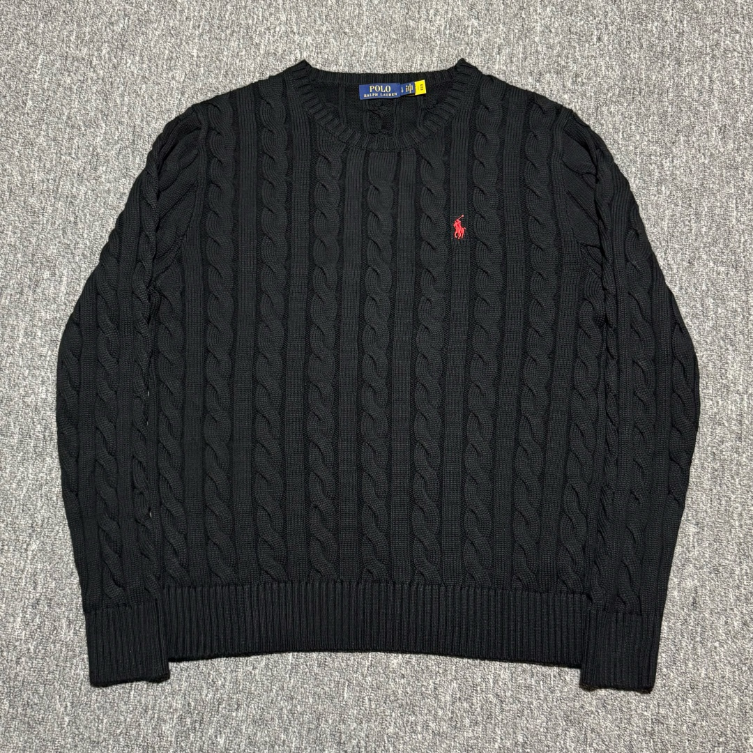 💰240  S# Ralph Lauren 拉夫劳伦 圆领绞花针织长袖毛衣 高端零售专供 品质保证 100%放心出街 尺码：S M L XL 编号：29OFTT82

面料克重： 380gsm 重磅毛衣的克重范围，确保了毛衣的挺括感、垂坠感和优异的保暖性。绞花图案需要足够的厚度才能立体突出

成分：100% 精纺新疆长绒棉 
既然是纯棉版，则使用100% 长绒棉。长绒棉纤维更长、强度更高、手感更柔软光滑，抗起球性优于普通棉花，是高端棉制品的首选

纱线工艺：
1.纺纱：使用精梳棉纱，去除了短纤维和杂质，纱线更光滑、坚固，不易起球。
2.合股：采用双股或多股纱线合捻编织。这大大增加了纱线的强度和织物的厚度，同时减少了变形几率，使织物结构更稳定，手感更丰满。
3.染色：采用色织或纱线染色。先对纱线进行染色后再编织，这样颜色渗透均匀，色牢度高，织物色泽柔和有层次感。水洗后颜色保持度高

布料的织造工艺：
1.绞花编织： 采用手工感模拟编织或电脑提花编织。通过交叉和扭绞针法，在平针的基础上形成立体的绳状、菱形、蜂窝等凹凸感强烈的图案。扭绞的力度和密度必须均匀一致，图案对称。要求绞花图案清晰、饱满、立体，触感有明显的凹凸层次。花型对位准确，尤其是在肩线、袖窿等接缝处。
2.底衫组织： 使用罗纹组织作为衣摆、袖口和领口，提供良好的收束力和弹性。 衣身主体部分在绞花图案之间会使用平针组织作为背景，以衬托绞花的立体感。平针部分应平整、无歪斜、无漏针
 3.领口、袖口、下摆罗纹：
使用与主面料同质同源的纱线，采用高弹性的棉混纺纱线（棉+氨纶），确保弹性和回复力优于衣身，能有效防止松懈变形。
4.螺纹工艺：采用 2x2 罗纹编织
要求织紧密实，弹性好，恢复性强。接缝处需平整
5.肩部加固： 使用与主布颜色匹配的棉质编带
在肩线内部的接缝处嵌入加固带。这能有效防止厚重的毛衣因自重而导致肩部拉伸变形，保持版型持久挺括。这是区分普通毛衣和高品质毛衣的关键细节

 辅料的工艺细节要求：
洗水标/主标：二维码领标 扫码可进官网

缝线材质：使用优质哑光棉线 其强度和色泽与主面料相匹配。缝骨（接缝）处采用四线拷边机处理，结实耐用。拼接处要对位准确（特别是绞花图案的对接），线迹均匀平整，无多余线头

原版定制三标辅料，与ZP一致