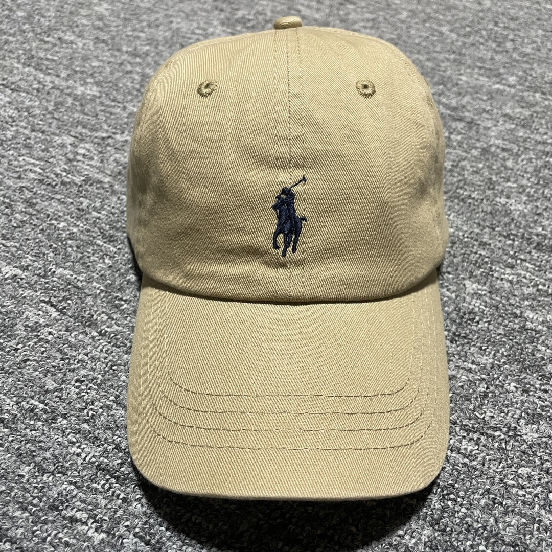 图片[2]-S# Ralph Lauren 拉夫劳伦 小马标 鸭舌帽 藏青/卡其 真正原版购回开发打版 高端零售专供 品质保证 100%放心出街 均码（52CM-62CM) 增礼佳品 ！附赠全套包装及定制手提袋 材质与工艺细节 主要材质 帽身： 采用高品质棉质帆（Cotton Twill）帆布材质紧密、硬挺有型，质感高级且耐磨 帽檐： 内部有内衬，采用轻质的聚合物板，使其能够轻松弯曲定形且不易折断，恢复性好 扣具： 金属按扣和棉质调节带，金属扣质感厚重，表面打磨光滑，刻有品牌Logo“Polo” 内里： 与头部接触的部分通常采用舒适吸汗的棉质或缎面材质，车线工整，不会有粗糙的线头 核心工艺细节： 刺绣工艺：清晰立体，标志性的Polo Player（马球手）Logo 或RL字母Logo 是核心，正品刺绣非常精致，针脚密集、均匀、饱满，图案边缘清晰锐利，无多余线头 色彩精准： 马球手的马鞍、马缰、球杆、衣服等不同部分的颜色区分清晰，即使是很小的细节也不会糊成一团 结构剪裁：帽身由6片面料拼接而成，拼接处的车线非常工整均匀，走线平直，弧度自然 定形工艺： 帽檐的弧度经过精心设计，既经典又现代。帽冠的弧线饱满，佩戴起来头型好看 重要鉴定点（真伪辨别） 假货（Fake）通常在以下细节上露出马脚 Logo刺绣 – 最重要的鉴定点 大货💯： 马球手Logo栩栩如生 马球杆： 球杆清晰可见，与手臂有区分 马腿： 至少能看到2-3条马腿的轮廓，线条分明 马鞍和马缰： 细节清晰，不会绣成一坨 整体比例： 马球手的身材比例协调，动作自然 市场版本❌： 刺绣粗糙、稀疏、扁平，马球杆可能看不清，马腿糊在一起，整体看起来呆板、畸形，充满廉价感 ！ 内部标签（Oxford Label） 真品材质： 通常是柔软的牛津布，质感好 印刷： 字体清晰、干净、粗细均匀“Ralph Lauren”字样精致-选品中心