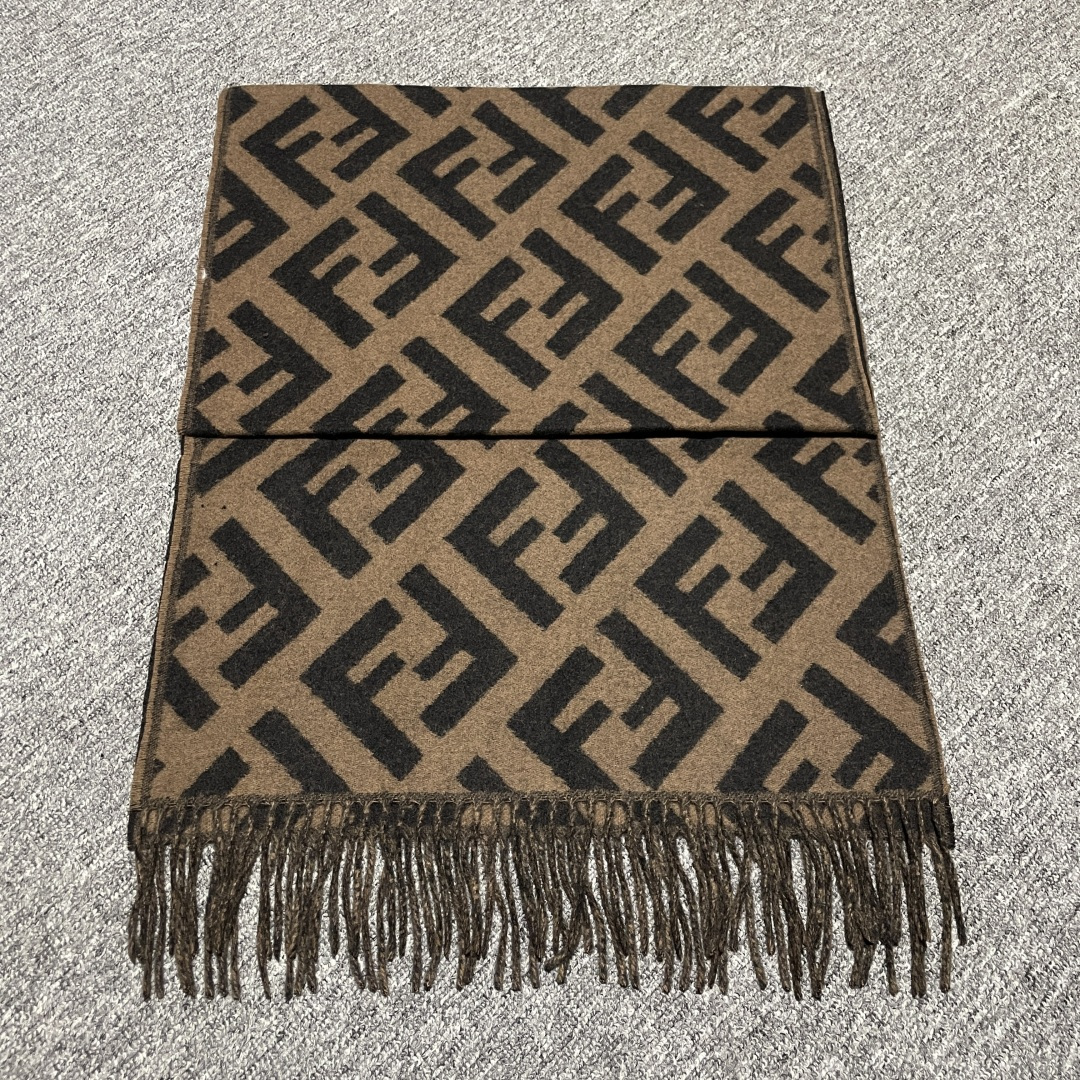 S# Fendi 芬迪 FF 羊毛提花围巾 高端零售专供 原版开发 品质保证 100%放心出街 材质：奢牌级“温柔铠甲” 严选澳洲美利奴羊毛×阿尔巴斯山羊绒黄金混纺，纤维细度堪比发丝1/5，触肤瞬间如坠云絮。秋冬交替时，克重经上百次调试——既能在微凉秋风中锁住暖意，又能于凛冽寒冬里化作贴身暖甲，轻若无物却暖如拥阳 工艺：毫米间的奢品密码 从纱线到成品，每一步都踩着“复刻原版”的精准刻度 老花织造：采用「双面提花工艺」，织机以0.1mm级精度复刻FF纹样的交错韵律，深棕与墨黑的撞色如油画笔触，立体浮雕感让老花在光影下“呼吸” 流苏艺术：每根流苏经“三梳三定”工序，长度误差≤1mm，手工捻制后自然垂坠，行走时随步伐轻晃，是静态围巾里藏着的动态诗意 边缘锁边：隐形包边技术让锁边如“隐形铠甲”，经5次水洗测试仍挺括如新，告别脱线变形，将奢侈品的“耐看度”刻进基因 复刻：从“形似”到“神同” 不止是纹样1：1，更是工艺精神的复刻： 色彩校准：采用Pantone奢侈品专属色卡，与专柜款色差＜0.5%； 织机参数：复刻米兰工坊老织机的转速、张力，让纱线捻度、纹路疏密分毫不差； 品控细节：每条围巾经7道质检，从毛边处理到流苏根数，皆对标专柜标准。 秋风掠过肩头时，它是风格的注脚；商务会晤间，它是低调的奢华暗号。当你指尖抚过提花的立体纹路，触摸到的不仅是顶级材质的温度，更是百年品牌对工艺的偏执坚守——这，才是复刻的意义 ⚠清洗建议：由于羊毛的材质特性，尽量干洗，尽量干洗，暴力机洗会出现缩水情况 ！如果觉得干洗一次太贵，有耐心的朋友也可以手洗，一定要冷水，且不能手搓！清洗后第一时间压干（不会滴水的程度）设计不能拧干！不能拧干！-选品中心