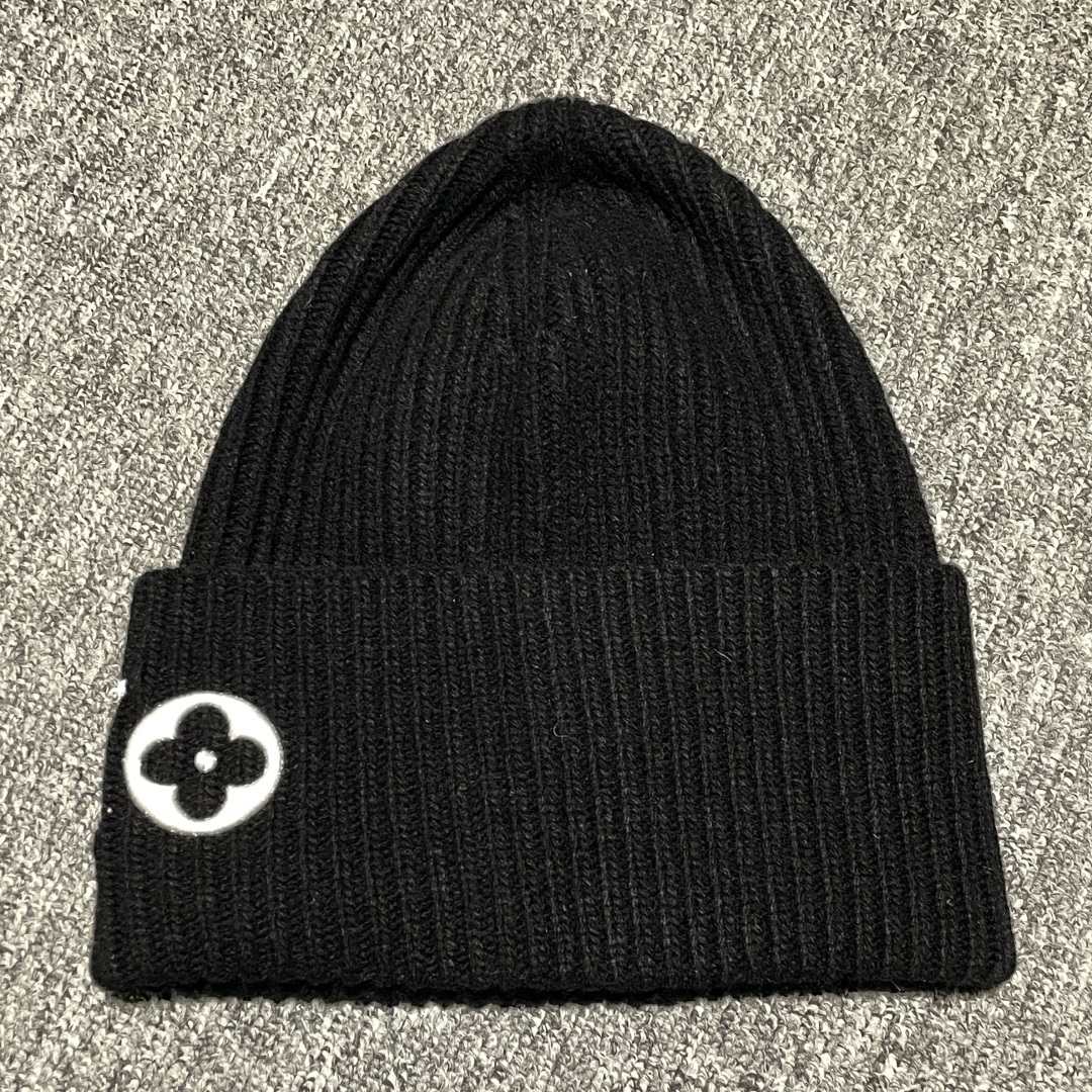 💰220  S# LV Monogram 驴家明星同款 针织冷帽 真正原版购回开发打版  高端零售专供 品质保证 100%放心出街 

🧶 工艺溯源：还原“奢适感”的针尖艺术

承袭品牌标志性Monogram基因，将LV老花符号与针织美学深度融合，是冬日街头潮奢态度的具象表达，让复古符号在当代衣橱里焕发新生

【材质甄选】

精选优质羊毛混纺面料，亲肤柔软如云朵轻覆，锁温性能拉满抵御寒潮；罗纹针织结构自带弹性，适配多元头围，长时间佩戴亦无束缚感，温暖与舒适双在线。

【工艺匠心】

• 刺绣工艺：采用高密度丝线进行立体刺绣，字母标识（LV）、经典图案（四叶花、菱形标）轮廓锐利如刀锋，触感饱满似浮雕，每一针都精准复刻原版的精致度与辨识度；

• 卷边设计：手工定型卷边工艺打造自然垂坠的宽边效果，弱化针织帽的厚重感，为整体注入随性感，冷风天里一顶叠戴也能凹出层次造型，实用性与风格感无缝衔接。

从秀场到街头，复刻的不只是一顶针织帽，更是法式奢华与实用主义共生的时尚哲学——让经典符号，在每一次佩戴中续写风格故事