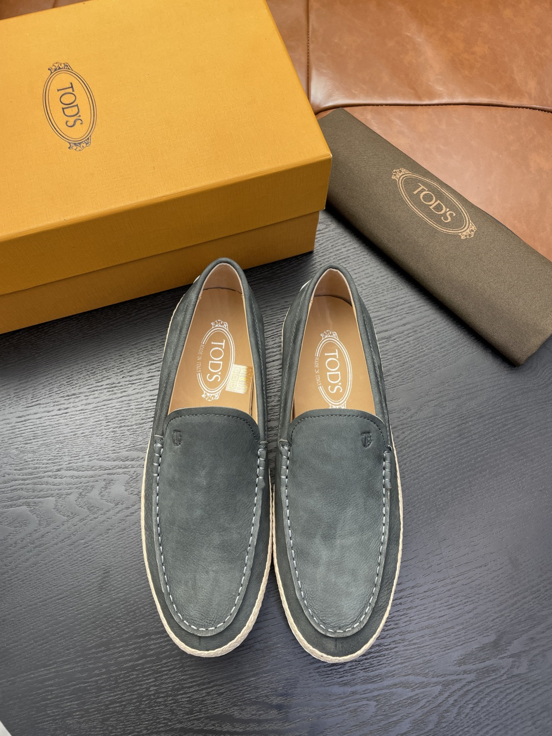 NO:930038,TODS's slip-on shoes are made of velvety suede leather, with Tod's letter trademark print, exposed stitching design, and the sole is decorated with woven raffia piping and rubber pebbles. Tod's men's slip-on shoes have suede leather upper, Tod's letter trademark print, rubber pebbles on the heel, leather insole, removable insole, and rubber bean non-slip and wear-resistant sole. It can easily interpret urban elegance, casual and versatile, and is an evergreen style in the shoe cabinet. It is worth having.  Code number 39-45,38,46 customized.,,Tod's19860909TODS托德斯本款便鞋以丝绒般的翻绒革制成,搭配Tod's字母商标印花、外露缝线设计,鞋底设有编织拉菲草嵌边和橡胶豆豆.Tod's男士便鞋·翻绒革鞋面,Tod's 字母商标印花,后跟点缀橡胶豆豆,皮革内底,可拆卸鞋垫,橡胶豆豆防滑耐磨鞋底,轻松演绎都市优雅品味,休闲百搭,鞋柜常青款,值得拥有. 码数39-45,38,46订做.,,Tod's,Men's shoes