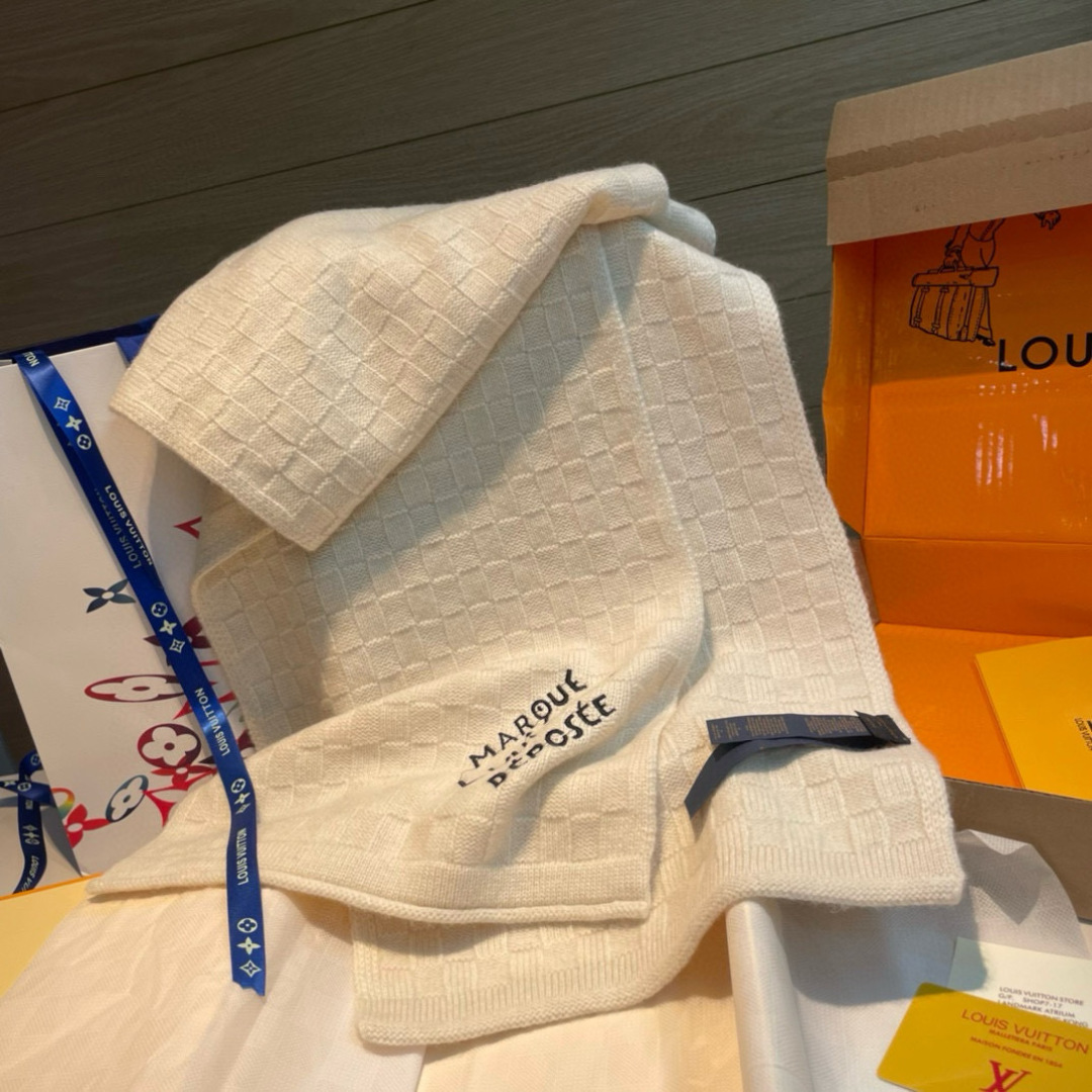 Damier Snug 围巾以绵羊毛针织呈现立体肌理，为 Pharrell Williams 创作的格纹