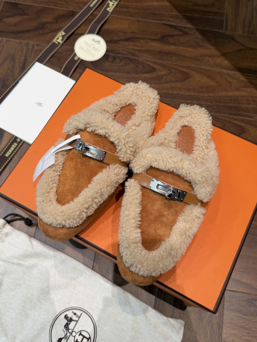 HERMES Mules mi-savates en peau et fourrure avec boucle Kelly