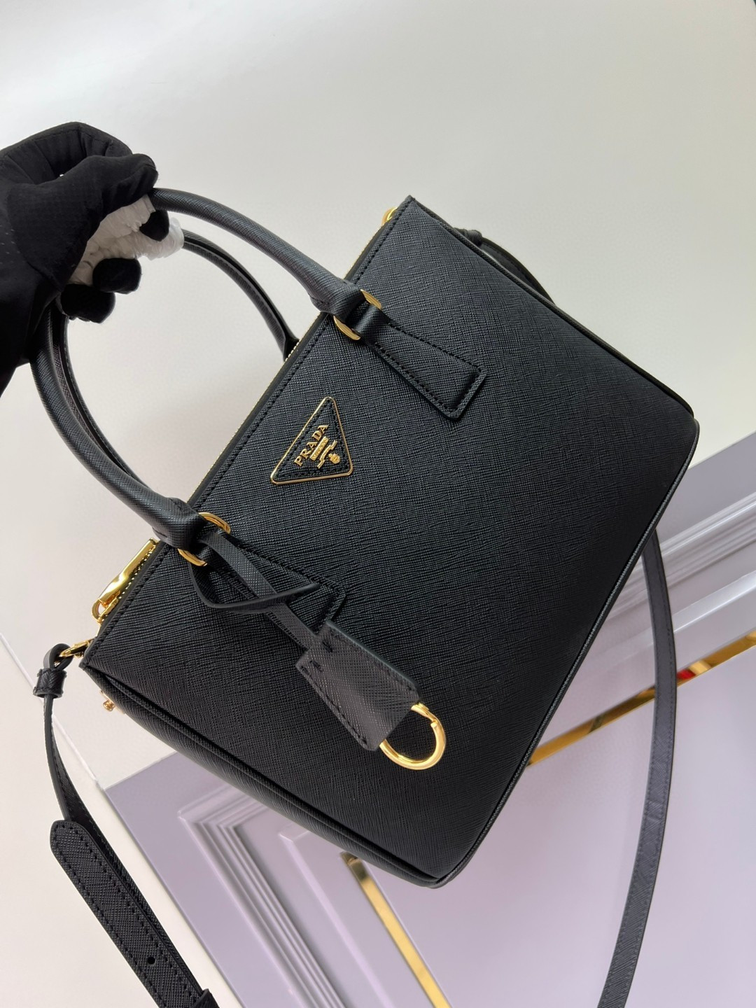 Small Prada killer bag, double handles in Saffiano leather. Detachable and adjustable leather shoulder strap. Gold-plated hardware. Triangular le
