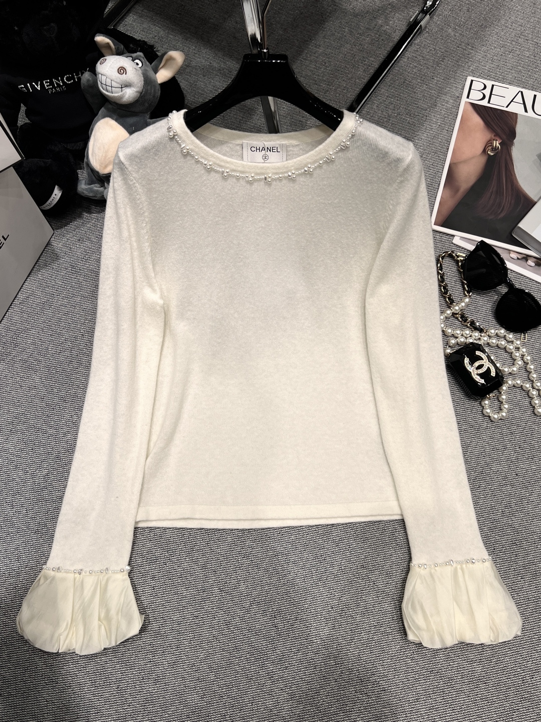 NO:549303,——CHANE*——The new knitted top of 2025 autumn and winter, adopts a round neck design, with pearl elements at the neckline, full of exquisiteness; the cuffs are trumpet-shaped, also embellished with pearls, and light yarn fabric is spliced ​​to add a soft atmosphere, chanel, alexander wang19860909——CHANE*——2025秋冬新款针织上衣,采用圆领设计,领口处珍珠元素,精致感十足；袖口为喇叭状,同样点缀珍珠,且拼接了轻盈的纱质面料,增添柔美气息,,chanel,alexander wang,Women's clothing