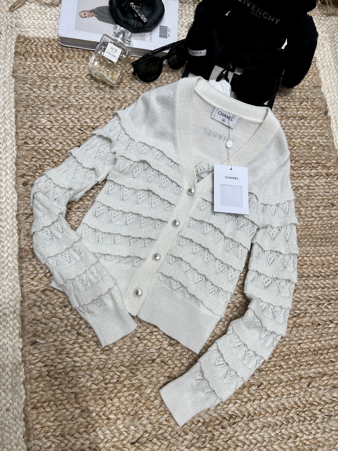 NO:775260,——Chane*——2026 SS This creamy white layer cake knitted cardigan is too fairy!  Layers of hollow crochet flowers + shimmering silver threads are gentle and a little delicate and noble, like wearing the spring moonlight on your body ~ V-neck + short version, it makes you slimmer and taller and can elongate your proportions. Wear it alone and you will look like a gentle lady. If you layer it with a suspender skirt, it will make you a date!  SML,Chanel-clothing,chanel,chanel,loro piana,skirts,19860909——Chane*——2026年SS 这件奶白层层蛋糕针织开衫也太仙了吧！ 层层叠叠的镂空钩花+微闪银丝,温柔又带点精致贵气,像把春日月光穿在身上～ V领+短款版型,显瘦显高还能拉长比例,单穿是温柔小姐姐,叠穿吊带裙就是约会天花板！SML,香奈儿-服装,chanel,chanel,loro piana,skirts,,Women's clothing