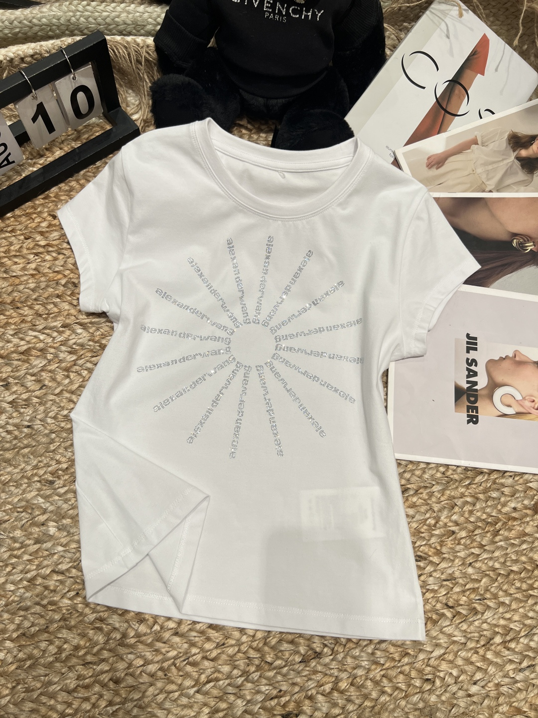 NO:830273,——Alexan* *Wan**——2026SS series hot diamond short-sleeved T-shirt, pure cotton material is soft and comfortable, and it is great to wear close to the body!  The radial hot-diamond logo on the front is super eye-catching under the light, making it highly recognisable. The slim-cut silhouette with straight shoulders and round neck design are simple and versatile. It can be easily worn in lazy style, hot girl style or sports style. It looks great with wide-leg pants and short skirts. You can easily switch styles for daily commuting or shopping. It is fashionable and practical!  SML,Alexander Wang-clothing,loro piana,alexander wang,skirts,T-shirt,tees,t-shirt,19860909——Alexan* *Wan**——2026SS 系列烫钻短袖T恤,纯棉材质柔软舒适,贴身穿着超赞！正面放射状烫钻Logo,灯光下blingbling超吸睛,辨识度满分.正肩修身剪裁,圆领设计简约百搭,无论慵懒风、辣妹风还是运动风都能轻松驾驭,搭配阔腿裤、短裙都很出彩,日常通勤或逛街都能轻松切换风格,时髦又实用！SML,亚历山大王-服装,loro piana,alexander wang,skirts,T-shirt,tees，t-shirt,,Women's clothing