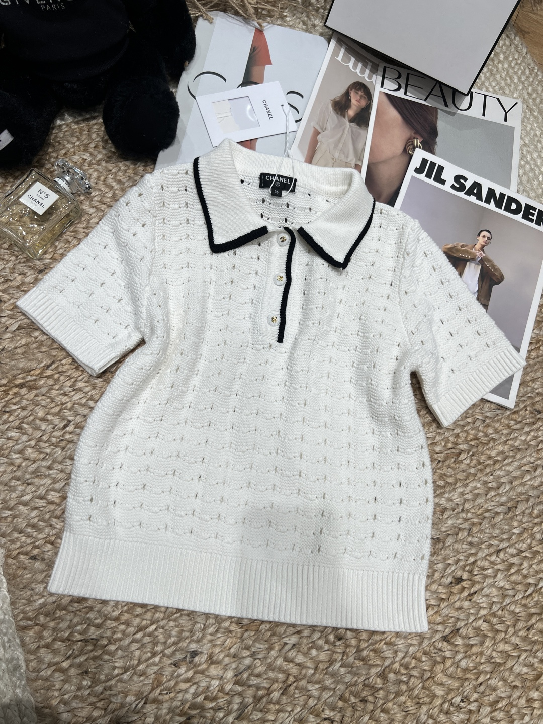 NO:854692,——Chane*——2026 SS hollow knitted Polo shirt, black lapel contrasting design is very recognizable!  The hollow knitting process makes the whole body more breathable, making it super comfortable to wear in spring and summer. Short sleeves + metal buttons, perfect details. Whether paired with jeans or a skirt, you can easily switch between casual or elegant styles. It is suitable for daily commuting, comfortable and fashionable!  SML,Chanel-clothing,chanel,chanel,loro piana,skirts,jeans,T-shirt,19860909——Chane*——2026年SS 镂空针织Polo衫,黑色翻领撞色设计超有辨识度！镂空针织工艺让整体更透气,春夏穿超舒服.短袖+金属纽扣,细节满分.无论搭配牛仔裤还是半裙,都能轻松切换休闲or优雅风,通勤日常都很适合,舒适又时髦！SML,香奈儿-服装,chanel,chanel,loro piana,skirts,jeans,T-shirt,,Women's clothing
