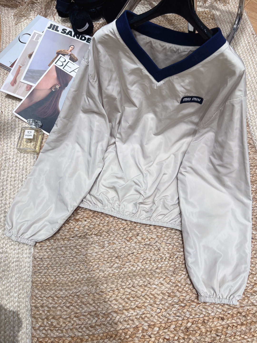 NO:854683,——Mi*M*u——2026 SS Miaojia L’ete series sweatshirt, made of high-density worsted polyester fiber material, soft satin texture, perfect drape and not easy to wrinkle. Loose fit + V-neck knitted stitching, brand logo on the chest, simple and detailed. Elastic cuff design, comfortable and fashionable, paired with the same series of bud skirts, you can easily control the college style or sports style, very suitable for daily outings and vacations! SML,Miu Miu-clothing,loro piana,skirts,19860909——Mi*M*u——2026年SS繆家L’ete系列运动衫,高密精纺聚酯纤丝材质,柔润缎光肌理,垂坠感满分不易皱.宽松版型+V领针织拼接,胸前品牌标识,简约又有细节感.袖口松紧设计,舒适又时髦,搭配同系列花苞短裙,学院风or运动风都能轻松驾驭,日常出街、度假都很适合！SML,缪缪-服装,loro piana,skirts,,Women's clothing