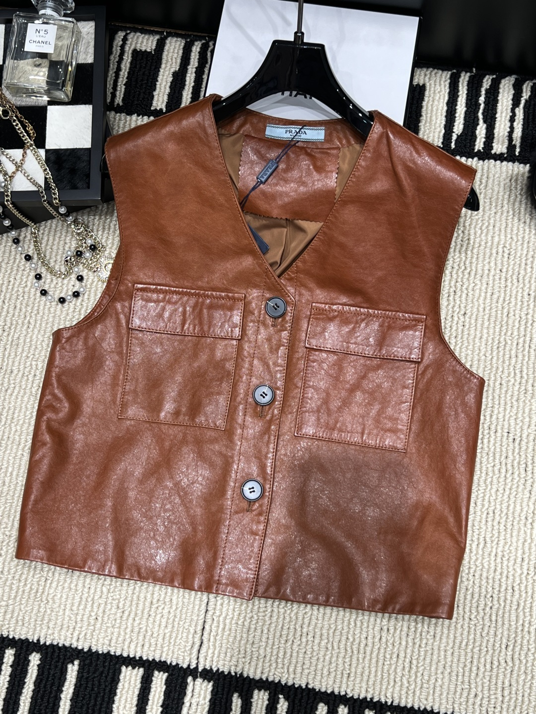 NO:931310,——Prad*——The new leather vest for autumn and winter 2026 is made of high-quality leather, with a natural luster on the surface and a soft touch. V-neck + front button design, with symmetrical flap pockets, practical and stylish, neat tailoring, super layered for autumn and winter!  Code numberSMLXL,,prada,19860909——Prad*——2026秋冬新款皮马甲,采用优质皮革,表面自然光泽,触感柔软.V领+正面纽扣设计,搭配对称翻盖口袋,实用又有型剪裁利落,.秋冬叠穿超有层次感！码数SMLXL,,prada,,Women's clothing