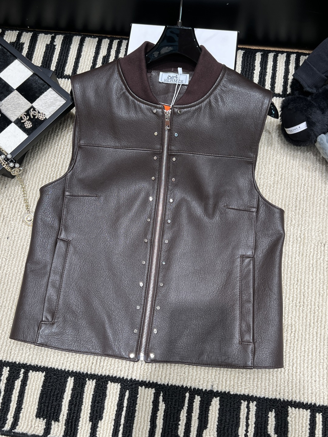 NO:942215,——Herme*——2026 Autumn and Winter New Hermès Studded Leather Vest Hermès 26 Spring and Summer Series Studded Leather Vest, made of black sheepskin, has a delicate texture and is durable. The round neck sleeveless design + metal rivets are tough and detailed. The front zipper opening and symmetrical pockets on both sides are practical and fashionable. The leather is soft, and it is great to layer or wear alone!  The rivet element makes the overall look more personalized and is a hot fashion item this season. Size S-XL, Hermès-clothing, hermes, hermes, loro piana, sheepskin,19860909——Herme*——2026秋冬新款爱马仕铆钉皮马甲 爱马仕26春夏系列铆钉皮马甲,黑色绵羊皮材质,质感细腻又耐用.圆领无袖设计+金属铆钉,硬朗又有细节感.正面拉链开合,两侧对称口袋,实用又时髦.皮质柔软,叠穿或单穿都很出彩！铆钉元素让整体造型更有个性,是本季超火的时尚单品.码数S-XL,爱马仕-服装,hermes,hermes,loro piana,sheepskin,,Women's clothing