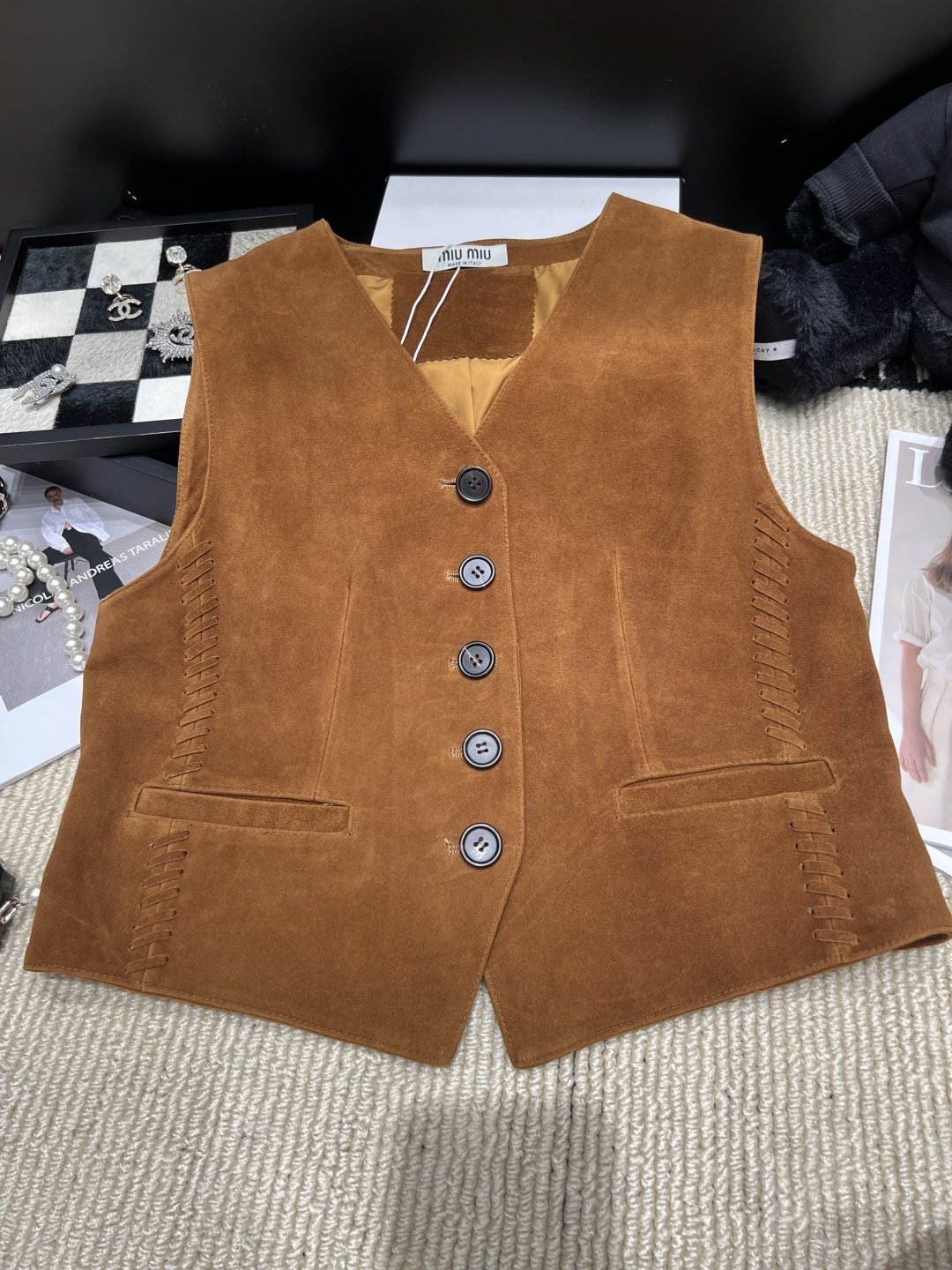 NO:944999,——MiuMi*——2026 new autumn and winter suede vest V-neck + single-breasted design, retro and simple, super versatile for autumn and winter wear!  The tassel details on both sides are super layered, and the pockets are practical and beautiful. Paired with jeans or long skirts, you can switch between being smart or feminine at will. It is also very good when layered. It is a must-have and practical item for autumn and winter wardrobes. Size SMLXL, Miumiu-clothing, miumiu, skirts, jeans, chamois leather,19860909——MiuMi*——2026秋冬新款麂皮绒马甲V领+单排扣设计,复古又简约,秋冬穿搭超百搭！两侧流苏细节超有层次感,口袋实用又美观.搭配牛仔裤或长裙,干练or柔美随心切换,叠穿也很出彩,是秋冬衣橱必备实用单品,码数SMLXL,缪缪-服装,miumiu,skirts,jeans,chamois leather,,Women's clothing