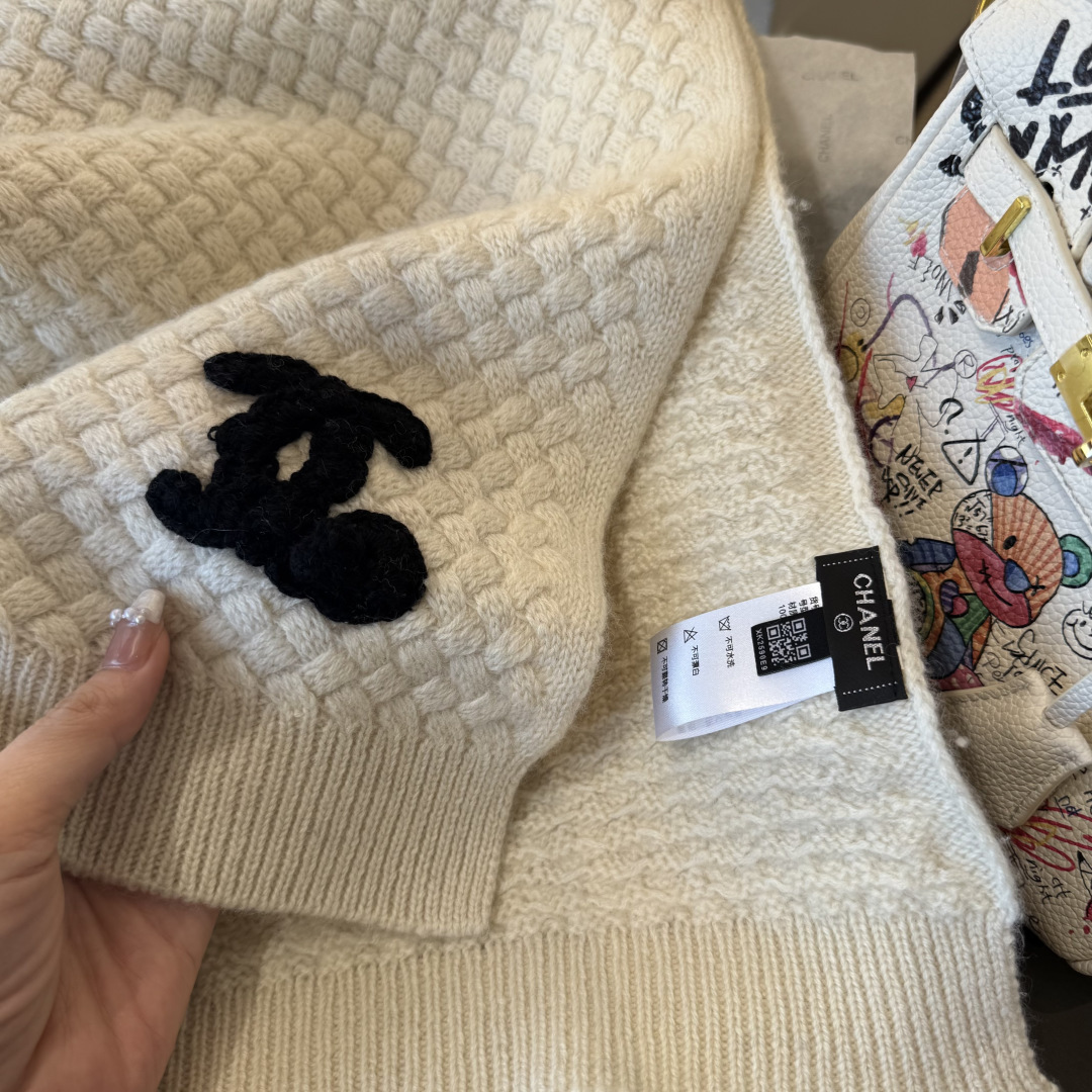 P220 【香奶奶针织鳞片花纹羊绒围巾】
以100%珍稀羊绒织就，
30*180cm修长尺寸如云朵般轻盈环绕颈间。鳞片纹理细腻灵动，
在光影间流淌着高级定制般的肌理之美。
重工手工编织双C茶花标识宛若艺术品，
每针每线皆凝聚匠心传承。
不仅是一件御寒配饰，更是移动的时尚名片羊绒温润质感与香奶奶优雅基因完美交融，无论是搭配大衣还是点缀针织衫，
都能瞬间提升整体造型的奢华指数。
这个冬日让经典茶花在颈畔绽放永恒魅力。