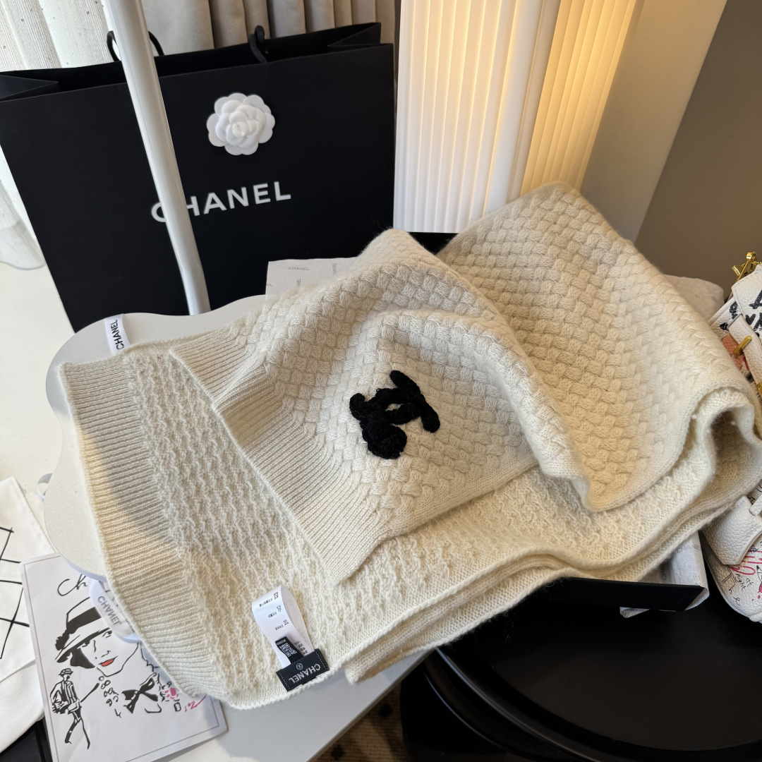 P220 【香奶奶针织鳞片花纹羊绒围巾】
以100%珍稀羊绒织就，
30*180cm修长尺寸如云朵般轻盈环绕颈间。鳞片纹理细腻灵动，
在光影间流淌着高级定制般的肌理之美。
重工手工编织双C茶花标识宛若艺术品，
每针每线皆凝聚匠心传承。
不仅是一件御寒配饰，更是移动的时尚名片羊绒温润质感与香奶奶优雅基因完美交融，无论是搭配大衣还是点缀针织衫，
都能瞬间提升整体造型的奢华指数。
这个冬日让经典茶花在颈畔绽放永恒魅力。