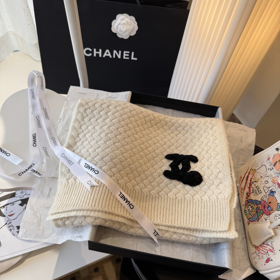 P220 【香奶奶针织鳞片花纹羊绒围巾】
以100%珍稀羊绒织就，
30*180cm修长尺寸如云朵般轻盈环绕颈间。鳞片纹理细腻灵动，
在光影间流淌着高级定制般的肌理之美。
重工手工编织双C茶花标识宛若艺术品，
每针每线皆凝聚匠心传承。
不仅是一件御寒配饰，更是移动的时尚名片羊绒温润质感与香奶奶优雅基因完美交融，无论是搭配大衣还是点缀针织衫，
都能瞬间提升整体造型的奢华指数。
这个冬日让经典茶花在颈畔绽放永恒魅力。