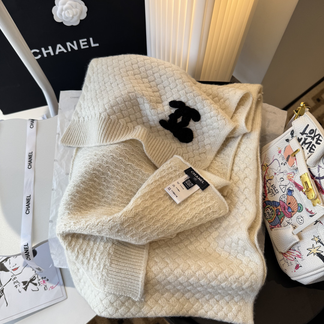 P220 【香奶奶针织鳞片花纹羊绒围巾】
以100%珍稀羊绒织就，
30*180cm修长尺寸如云朵般轻盈环绕颈间。鳞片纹理细腻灵动，
在光影间流淌着高级定制般的肌理之美。
重工手工编织双C茶花标识宛若艺术品，
每针每线皆凝聚匠心传承。
不仅是一件御寒配饰，更是移动的时尚名片羊绒温润质感与香奶奶优雅基因完美交融，无论是搭配大衣还是点缀针织衫，
都能瞬间提升整体造型的奢华指数。
这个冬日让经典茶花在颈畔绽放永恒魅力。