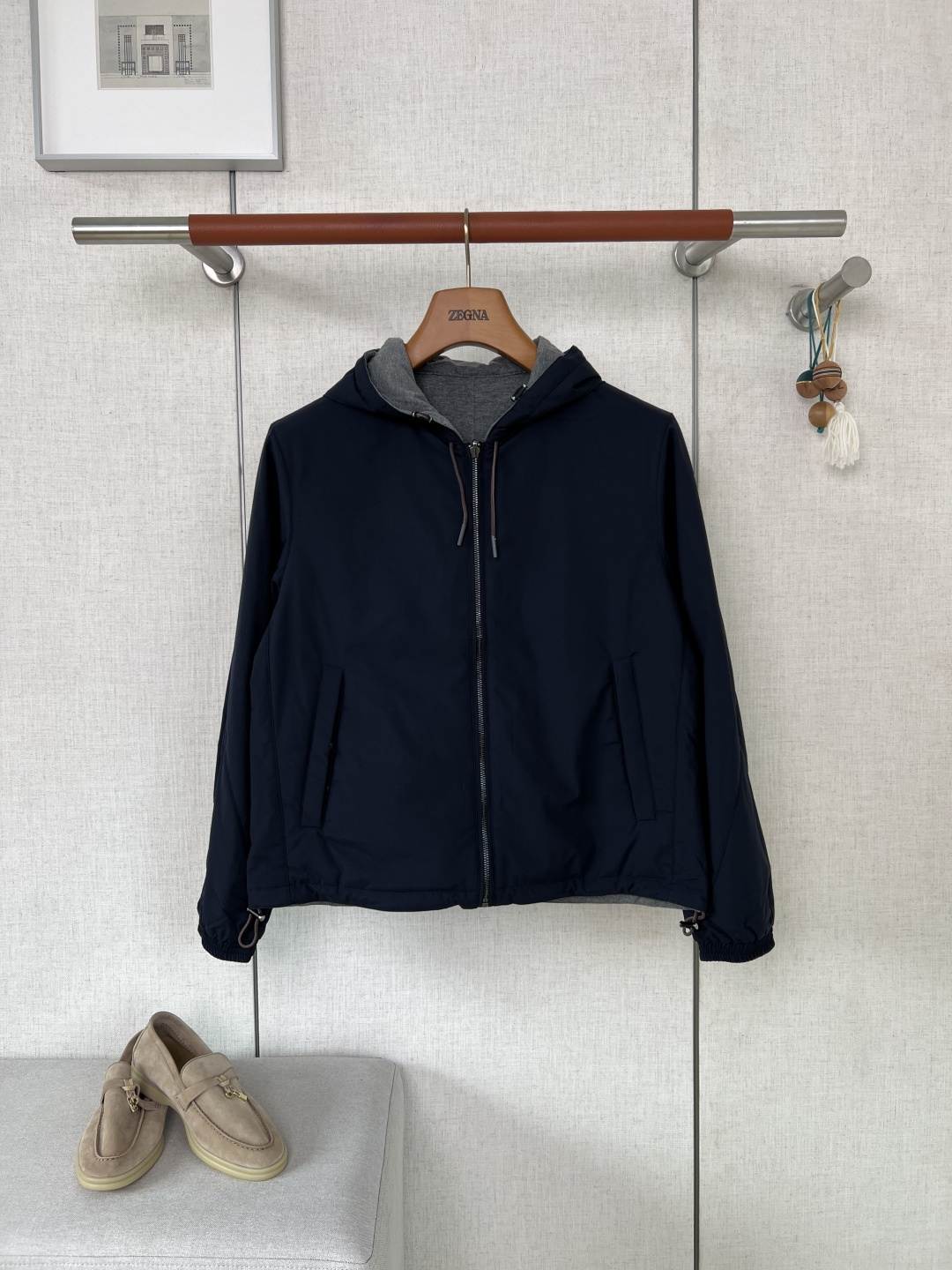 NO:957477,ZEGNA Reversible Hooded Casual Jacket #8862088  The fabric is configured differently on two sides. The outer fabric is made of high-density windproof functional fabric. The fabric surface is smooth and crisp, with good windproof and mild water-repellent properties. The reverse side is made of fine knitted wool-like fabric, which feels soft and skin-friendly. It has basic warmth retention properties and is suitable for wearing in cool weather. The double-sided fabrics are color-fixed and shaped, so they are not easy to fade after washing and the pattern is difficult to loose and deform.  The drawstring of the hat is made of woven fabric, and the end is etched with 'Ermenegildo'  Zegna' matte metal headband, high-end and wear-resistant texture, the cap opening can be tightened freely to avoid draft problems, the front zipper adopts a smooth metal zipper, with a low probability of jamming during the pulling process, and the edges of the zipper are neatly routed; the hem and cuffs are equipped with adjustable drawstrings  The mouth can be tightened as needed to lock in heat and wind, and optimize the fit of the garment; the left chest of the knitted surface is equipped with a brown embroidered brand's cursive logo, the stitching is dense and three-dimensional, and the embroidery thread is firm and not easy to get off-line and fuzz; the diagonal embedded pockets are solidly routed, and the items are not easy to deform and crack.  The whole body piece is cut symmetrically by lathe workmanship, and the splicing areas are all precision seamed and reinforced. The hemming transition of the double-sided fabric is smooth and without bulges, and there are no rough edges or messy exposed threads. The color matching line is adapted to the background color of the fabric, making it highly concealable and in line with the brand's low-key and elegant workmanship standards.  The fit is neat and slightly loose, with a short cut that flatters the body shape without looking bloated. The neat lines are suitable for both light business commuting and daily urban travel. It supports double-sided rotation, with black and navy blue shell colors, and the look and feel of two fabrics can be switched. One jacket unlocks a variety of dressing styles.  At the quality control level, multi-layer quality inspection is carried out on fabrics' water pressure resistance, stitching firmness, and embroidery points. Garments with color differences, blurred hardware markings, and embroidery jumpers are all scrapped. The material loss is relatively high. The materials and craftsmanship are a step above ordinary commuter jackets. It is suitable for men who prefer simple and high-end men's clothing and pursue the utilization of single products. Color matching black/navy blue (double-sided functional windproof fabric surface + hemp gray knitted lining)  Size S/M/L/XL/2XL,,zegna,jackets & coats,jackets & coats,hats,19860909ZEGNA杰尼亚双面可穿连帽休闲夹克  #8862088 面料分两面做差异化配置外层面料选用高密防风机能面料,布面顺滑挺括,自带不错的防风、轻度防泼水性,反面为细腻针织毛感面料,触感软糯亲肤,具备基础保暖属性,适配微凉天气穿搭,双面面料均做固色定型处理,洗护不易掉色、版型难松垮变形 帽部抽绳为编织布艺材质,端头配置蚀刻「Ermenegildo Zegna」字样哑光金属束头,质感高级耐磨,可自由收紧帽口规避灌风问题,正面拉链选用顺滑金属拉链,拉动过程卡顿概率低,拉链边缘走线工整；下摆、袖口配有可调节抽绳收口,按需收紧后可以锁温防风,优化衣身合身度；针织面左胸搭载棕色刺绣品牌草书logo,针脚密实立体,绣线牢靠不易脱线起毛；斜向嵌入式口袋走线扎实,置物不易变形开裂. 车工做工整件衣身裁片对称裁切,拼接处全线精密锁边加固,双面面料的包边过渡平整无凸起,不存在毛边、杂乱外露线头；配色走线随面料底色适配,隐蔽性强,契合品牌低调奢雅的做工标准 版型穿搭利落微宽松短款剪裁,修饰身形不显臃肿,利落的线条适配轻商务通勤、都市日常出行两种场景；支持双面轮换穿搭,黑色、藏青两款外壳配色,可切换两种面料观感,一件夹克解锁多样穿搭风格. 品控层面面料耐水压、缝线牢固度、刺绣点位均做多层质检,面料产生色差、五金刻印模糊、刺绣跳线的成衣统一报废处理,物料损耗偏高,用料与工艺质感甩开普通通勤外套一档,适配偏爱简约高级男装、追求单品穿搭利用率的男士 配色黑色/藏青色（双面机能防风面料面+麻灰针织内里） 尺码S/M/L/XL/2XL,,zegna,jackets & coats,jackets & coats,hats,,Men's clothing