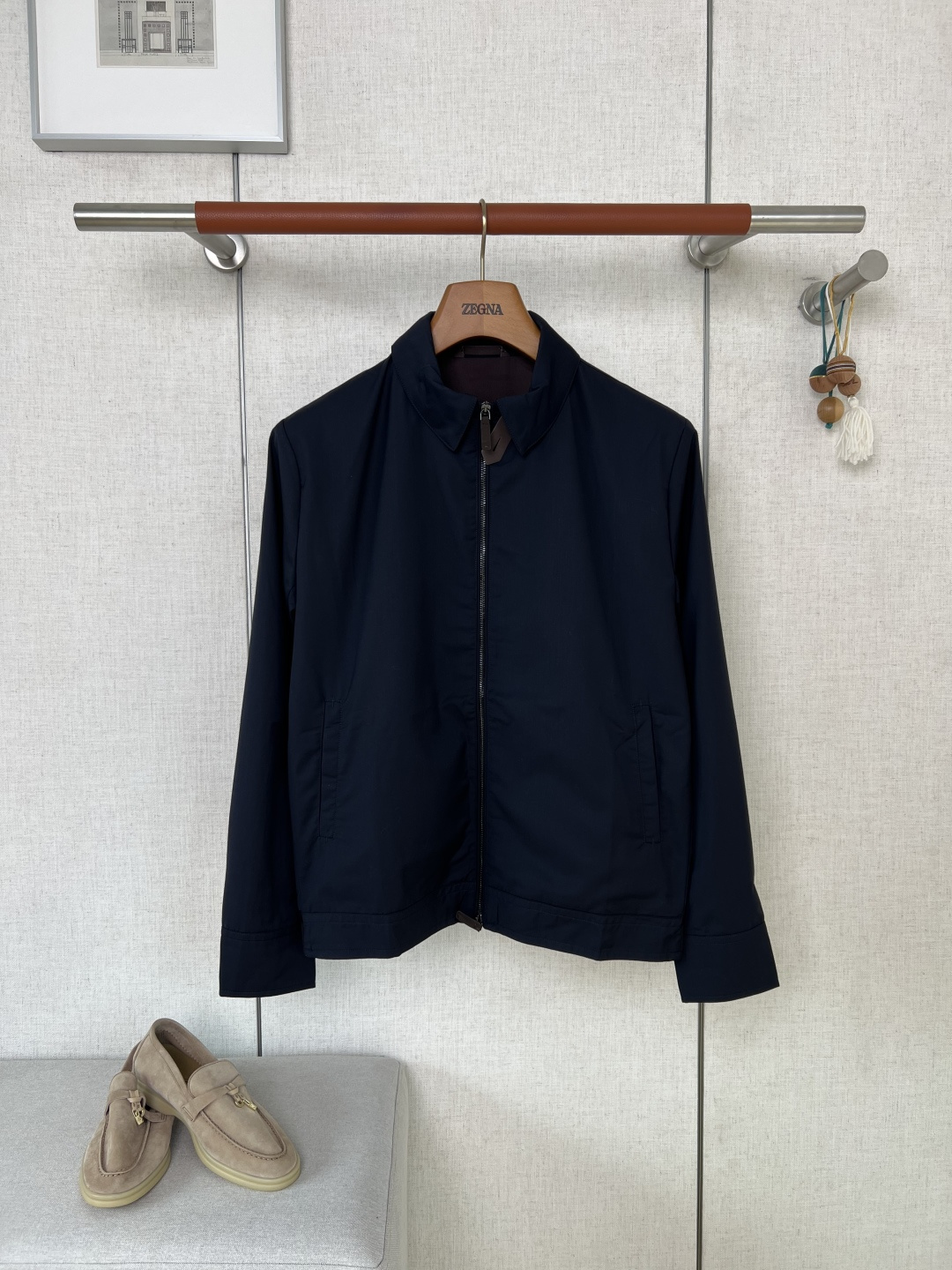 NO:957499,ZEGNA Navy Blue Lapel Double-Zip Business Jacket #8872088 The brand's exclusive high-end anti-wrinkle functional fabric is selected. The fabric texture is fine and smooth, showing a high-end low-key matte color. The deep navy blue has been treated with high-standard color fixation technology. The fabric has both moderate stiffness and breathability, and has good windproof properties.  The main placket is equipped with the brand's classic double-open smooth metal zipper, and the zipper accessories are matched with polished and warm leather pull tabs. The opening and closing process is smooth and wear-resistant, and there is no jamming or loosening of the teeth. The collar is equipped with custom buttons engraved with the brand logo. The buttons are regular in shape and have clear engraved lines, which can be used to fine-tune the collar shape. The embedded hidden pockets on both sides are tightly routed and the bag mouth is reinforced with multi-layer stitching. The bag mouth will not be pulled, deformed or cracked after long-term use.  The entire inside of the garment is made of precision overlock stitching. The stitches are uniformly spaced and tightly arranged. There are no loose and exposed floating thread ends. The seams of the body are joined with double-thread reinforcement technology. Dark fabrics are matched with same-color stitching to eliminate problems of skipping threads and skewed stitches. By touching the inside with your hands, you can intuitively feel the precision of the benchmark counter.  It is a neat formal dress with a small lapel shape. You can adjust the opening and closing of the neckline by relying on the collar button. There is no exaggerated printing or exposed large logos. It relies on simple tailoring to create a light and luxurious texture. The straight fit body tailoring can modify the bloated lines of the upper body. The cuffs are closed with flat seams and the hem is shaped with multi-layered lines to prevent curling. It is suitable for men of all ages.  The yarn weaving arrangement of the fabric is dense and even, and there are no defects such as local sparse yarns or thickness differences. All garment pieces are cut strictly according to the original sample. The position of the left and right pockets, the length of the sleeves on both sides, and the left and right width of the body are controlled within a very small range. This avoids the defects of piece misalignment and left and right asymmetry that are common in mass production, and the symmetry of the garment pieces is excellent.  This business jacket has raised the bar for garment production in several processes including fabric color fixation, exclusive accessory assembly, and multi-piece symmetrical cutting. Defects in the fabric and substandard wiring will be directly scrapped, and the loss of raw materials has increased significantly. The hard-core workmanship has widened the texture gap between ordinary and affordable jackets. Consumers who prefer low-key luxury men's clothing and value the workmanship of ready-made garments can easily distinguish the obvious differences in grade. Color Navy Size  48/50/52/54/56,,zegna,jackets & coats,jackets & coats,19860909ZEGNA杰尼亚藏青色翻领双拉链商务夹克  #8872088 甄选品牌专属高定抗皱机能面料,布面肌理细腻顺滑,呈现高级低调哑光色泽,深藏青经过高标准固色工艺处理,面料兼顾适中挺括度与透气性,自带不错的防风属性 主门襟配置品牌经典双开顺滑金属拉链,拉链配饰搭配打磨温润的真皮拉牌,开合过程顺滑耐磨,不存在卡顿卡布、齿位松动故障；领部加装雕刻品牌标识的定制纽扣,纽扣版型规整、刻印纹路清晰,用于领型塑形微调；两侧嵌入式暗袋走线密实规整,袋口做多层车线加固,久用袋口不会拉扯变形开裂. 整件成衣内里全域做精密包缝走线,各处针脚间距统一、排布紧实,不存在松散外露的浮线头,衣身拼接接缝位置采用双线补强工艺.深色面料搭配同色系缝线,杜绝异色跳线、针脚歪斜问题,上手摩挲内里,能够直观感受到对标专柜的精致做利落正装小翻领版型,可依靠领扣调整领口开合状态,无夸张印花、外露大logo,依靠简洁剪裁塑造轻奢质感；直筒合身衣身剪裁可以修饰上身臃肿线条,袖口做平整锁边车线收口,下摆多层压线定型不易卷边；适配各年龄段男士. 面料纱线织造排布致密均匀,不存在局部纱线稀疏、厚薄落差的瑕疵；成衣全部裁片严格对标原版样板裁切,左右口袋位置、两侧袖管长短、衣身左右宽度误差控制在极小区间,规避通货批量生产常见的裁片错位、左右版型不对称缺陷,成衣裁片对称度表现优异 这件商务夹克在面料固色定型、专属辅料装配、多裁片对称裁切几道工序拉高了成衣制作门槛,面料瑕疵、车工走线不达标都会直接报废处理,原料损耗大幅上涨,硬核做工拉开和平价外套的质感差距,偏爱低调轻奢男装、看重成衣做工质感的消费者,可轻松分辨品级层面的明显差别 颜色 藏青色 尺码 48/50/52/54/56,,zegna,jackets & coats,jackets & coats,,Men's clothing