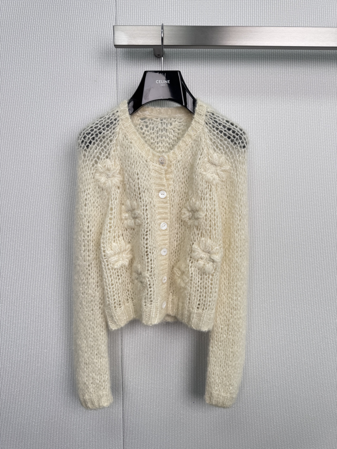 NO:578231,CELINE2025 new autumn and winter knitted cardigan, a light narrative of French elegance. This light beige cardigan uses exquisite hollow crochet technology to outline a delicate texture like plant veins between soft yarns, and the V-neck is smooth.  Extending the neck line, four mother-of-pearl textured buttons adorn the front like morning dew, forming a gentle dialogue with the three-dimensional blooming velvet-like flowers on the body - each flower stamen is hand-embellished by craftsmen, continuing Phoebe between virtual and solid.  The minimalist romanticism of the Philo era. When your fingertips brush through the lace-like transparent mesh fabric, you can feel as if you can touch the whispers of the sycamore trees blowing in the wind in the left bank cafe in Paris. Whether it is worn with a silk suspender skirt to interpret the lazy evening breeze aesthetic, or with a  Paired with white jeans to create a daytime French style, this cardigan can become a breathing work of art in your wardrobe with a light weight. When the morning light passes through the hollow patterns and casts mottled patterns on the ground, you have already worn the morning sun on the Seine River on your body.  Size SML,,celine,skirts,jeans,real silk,alexander wang19860909CELINE2025秋冬新款针织开衫,法式优雅的轻盈叙事,这件浅米白色开衫以精妙的镂空钩花工艺,在柔软纱线间勾勒出植物脉络般的细腻纹理,V领剪裁流畅延伸颈部线条,四颗珍珠母贝质感纽扣如晨露般点缀前襟,与衣身立体绽放的绒感花朵形成温柔对话——每一朵花蕊皆由匠人手工缀饰,在虚实交错间延续Phoebe Philo时代的极简浪漫主义,当指尖拂过蕾丝般通透的网眼织面,仿佛能触摸到巴黎左岸咖啡馆里,随风飘散的梧桐絮语,无论是内搭真丝吊带裙诠释慵懒晚风美学,还是搭配白色牛仔裤演绎日间法式风情,这件开衫都能以举重若轻的形态,成为你衣橱里会呼吸的艺术品,当晨光穿过镂空花纹在地面投下斑驳时,你已将塞纳河畔的晨曦穿在了身上. 码数SML,,celine,skirts,jeans,real silk,alexander wang,Women's clothing