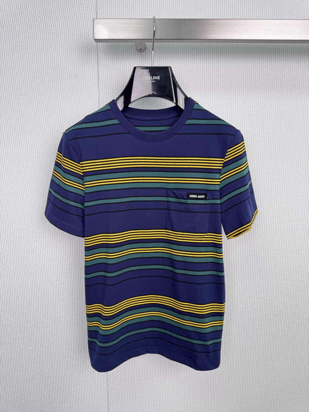 NO:588425,MiuMiu 2025 new winter striped T-shirt, classic renewal, color play, dark blue background meets yellow and green stripes, like waves colliding with neon spectrum, black brand logo on the left chest, using minimalist details to declare extraordinary status, comfortable cotton fabric, outlines a relaxed figure, straight casual cut, suitable for multiple wear, iconic color combination, breaking the monotony of basic styles, white jeans = French seaside holiday style, black leather skirt =  Sweet and cool mix-and-match equation, wear alone with a crossbody bag = 3-minute fashion solution for going out. Size SML, miumiu, satchels, crossbody bags, skirts, jeans, tees, t-shirt, alexander wang19860909MiuMiu2025冬季新款条纹T恤,经典焕新,色彩游戏,深蓝底蕴邂逅黄绿条纹,如同海浪碰撞霓虹光谱,左胸点缀黑色品牌标识,以极简细节宣告不凡身份,舒适棉质面料,勾勒轻松身形,直筒休闲剪裁,适配多元穿搭,标志性色彩组合,打破基础款单调,白色牛仔裤 = 法式海滨假日风,黑色皮裙 = 甜酷混搭方程式,单穿配斜挎包 = 3分钟出门时尚解法. 码数SML,,miumiu,satchels,crossbody bags,skirts,jeans,tees，t-shirt,alexander wang,Women's clothing