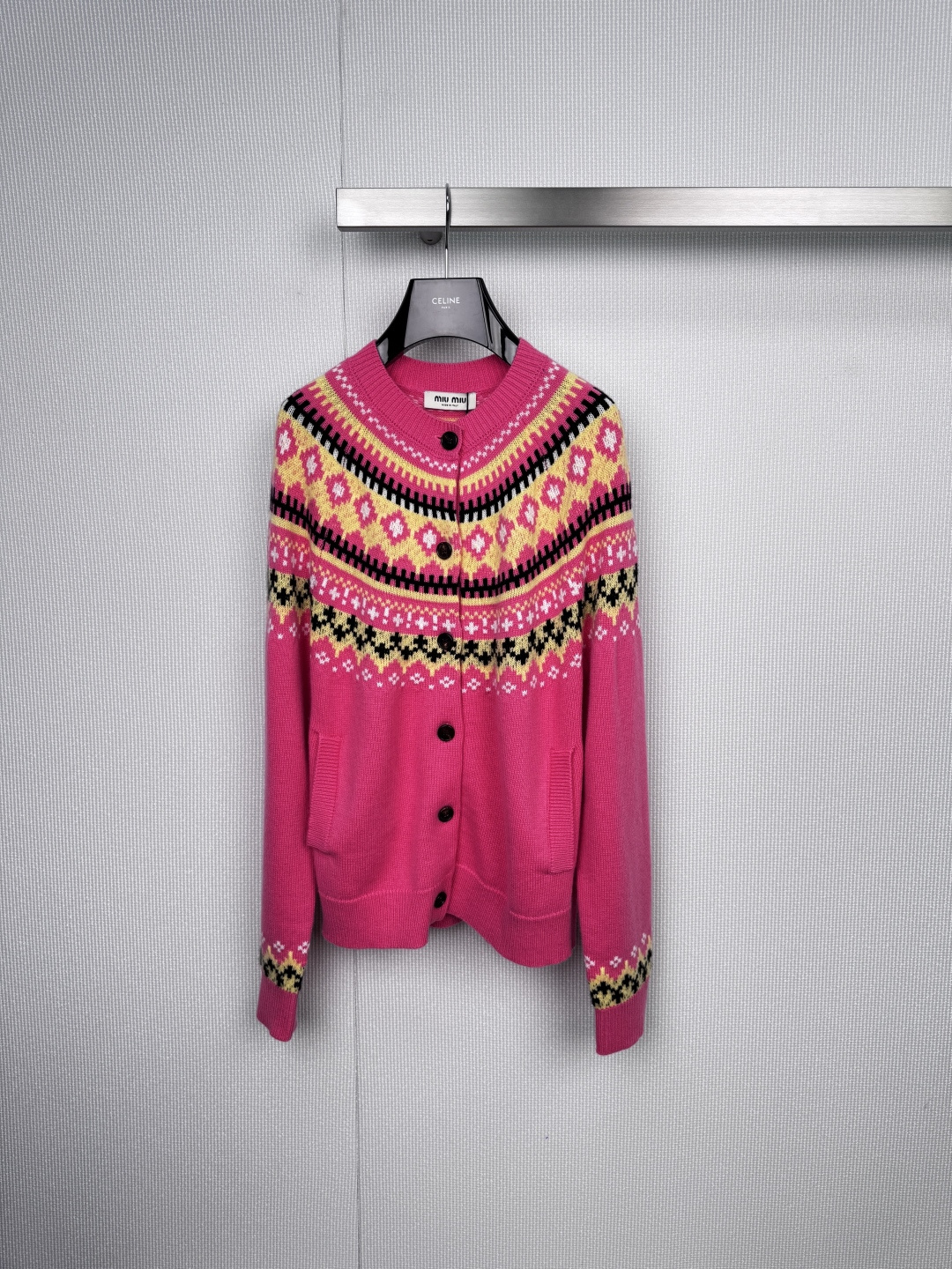 NO:589570,Miu Miu's sweet and cool magic, this Fair Isle jacquard cardigan is too girly, pink warning, your retro wardrobe needs this 'sugar-rich' Miu  The iconic bright pink tone of the Miu cardigan instantly brightens up the dull autumn and winter. The classic Fair Isle jacquard on the collar, cuffs and hem is the soul. The three colors of black, yellow and white are intertwined to create rhombus, flower and cross patterns, which directly adds a retro feel. The round neck design is cute and cute, but with eye-catching black buttons and practical side pockets, it also reveals a hint of uninhibited college style. Whether worn with a shirt skirt or jeans, you can easily interpret Miu  The unique sweetness and rebelliousness of Miu girls.,,miumiu,skirts,jeans,shirts,alexander wang19860909MiuMiu的甜酷魔法,这件费尔岛提花开衫也太戳少女心了,粉色预警,你的复古衣橱需要这件“糖分超标”的Miu Miu开衫,标志性的鲜亮粉色调,瞬间点亮沉闷秋冬,领口、袖口与衣摆的经典费尔岛提花是灵魂所在,黑、黄、白三色交织出菱格、花朵与十字图案,复古感直接拉满,圆领设计乖巧讨喜,但配上醒目的黑色纽扣和实用的侧边口袋,又透着一丝不羁的学院风,无论是内搭衬衫裙还是搭配牛仔裤,都能轻松演绎Miu Miu女孩独有的甜美与叛逆.,,miumiu,skirts,jeans,shirts,alexander wang,Women's clothing